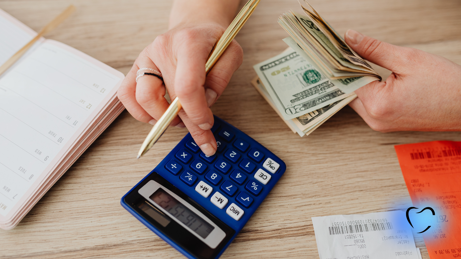 Person using calculator and counting money with receipts and notepad on a table.