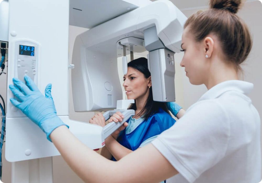A woman is getting an x-ray of her teeth in a dental office.