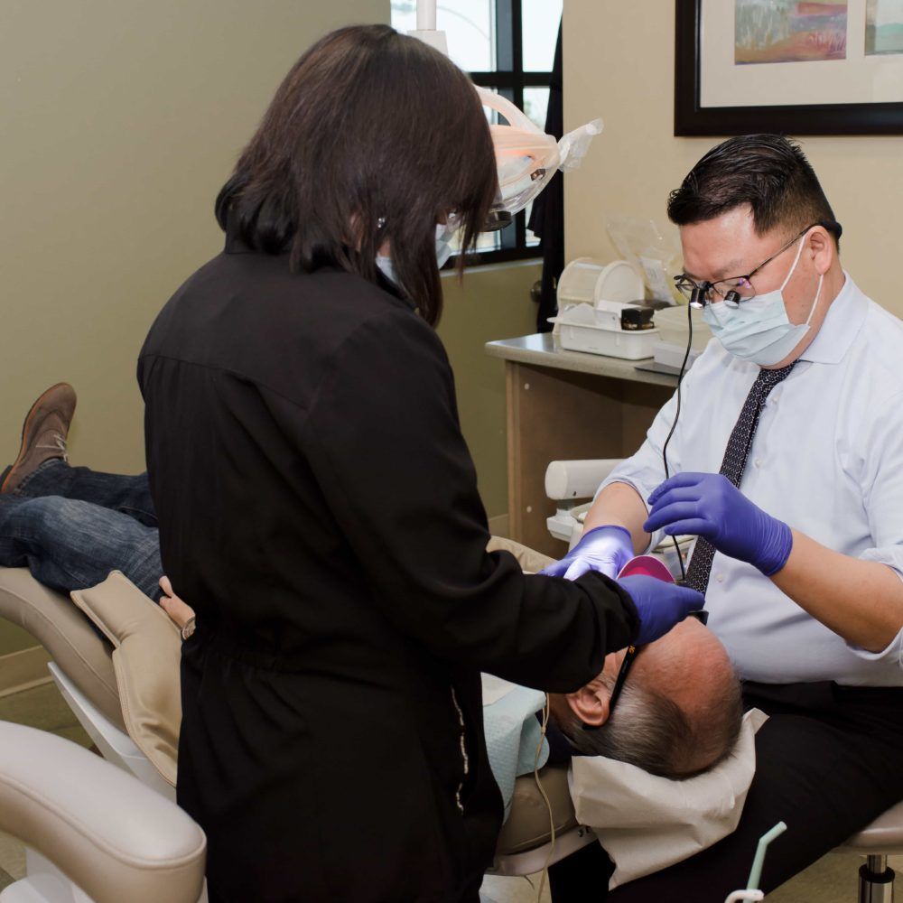 A man is getting his teeth examined by a female dentist