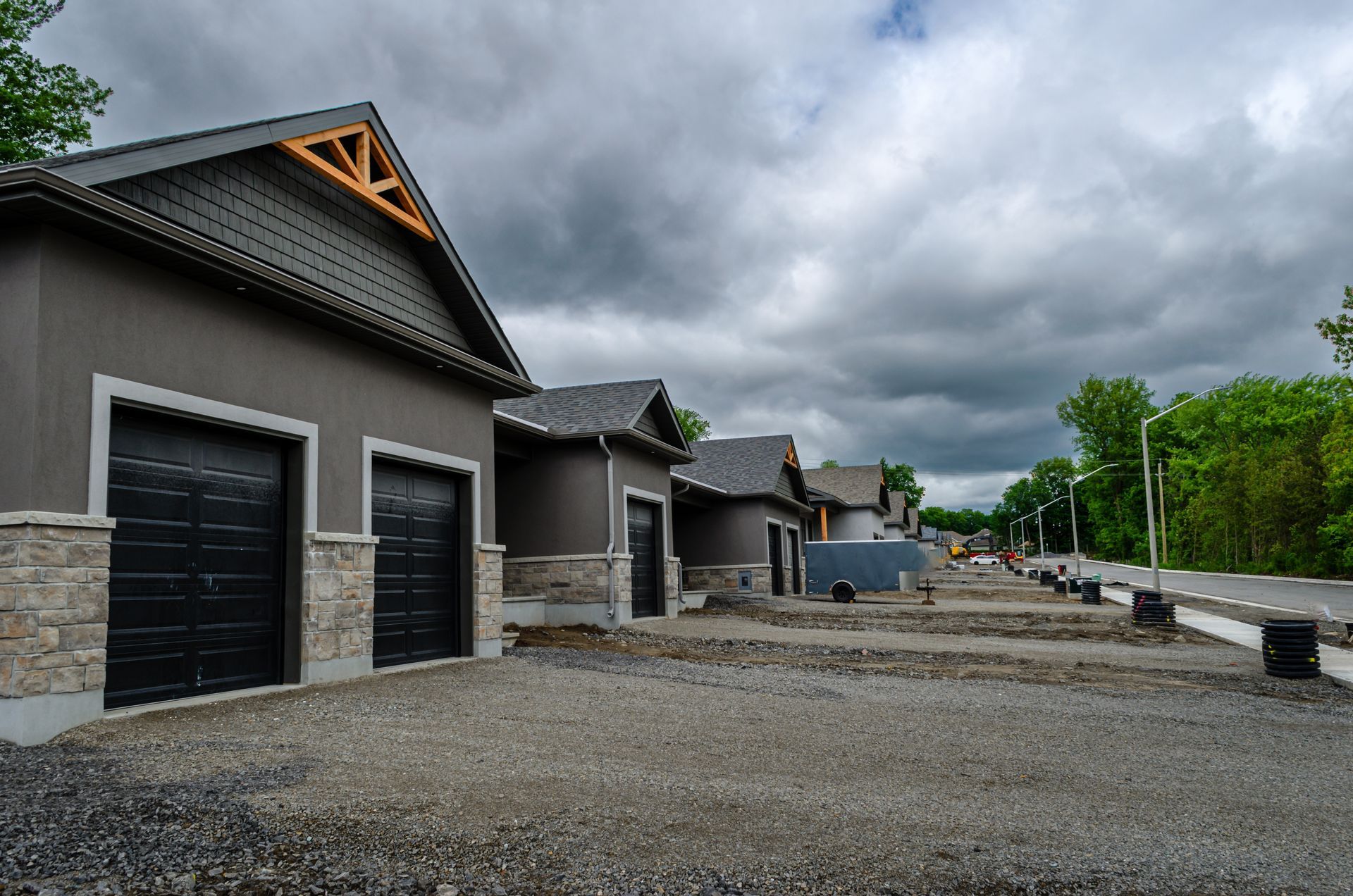 Woman in brown top talking, hands clasped, at a table with a laptop, facing a person holding a tablet.
