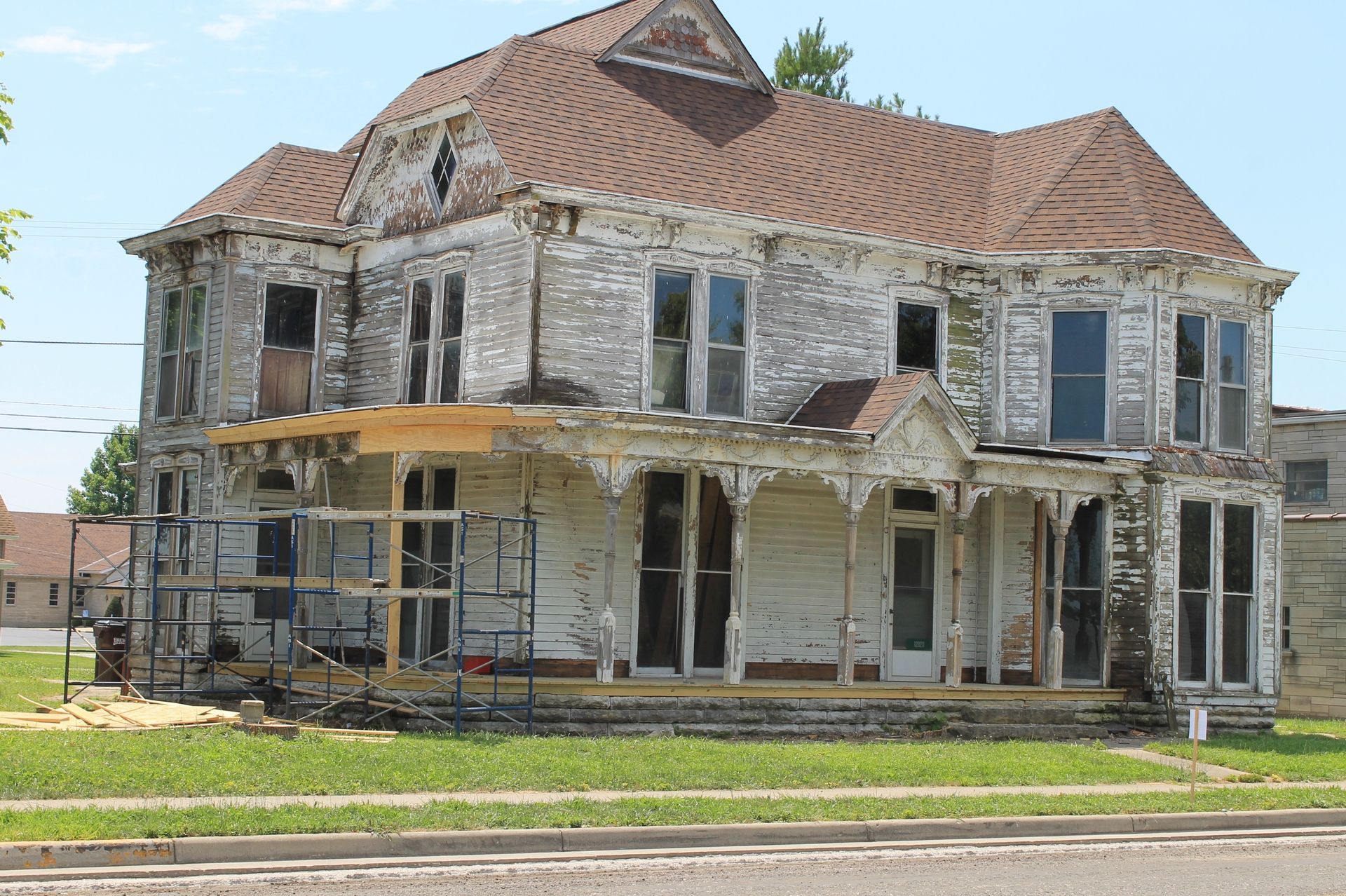 Couple reviewing blueprints with a real estate agent in an empty home.