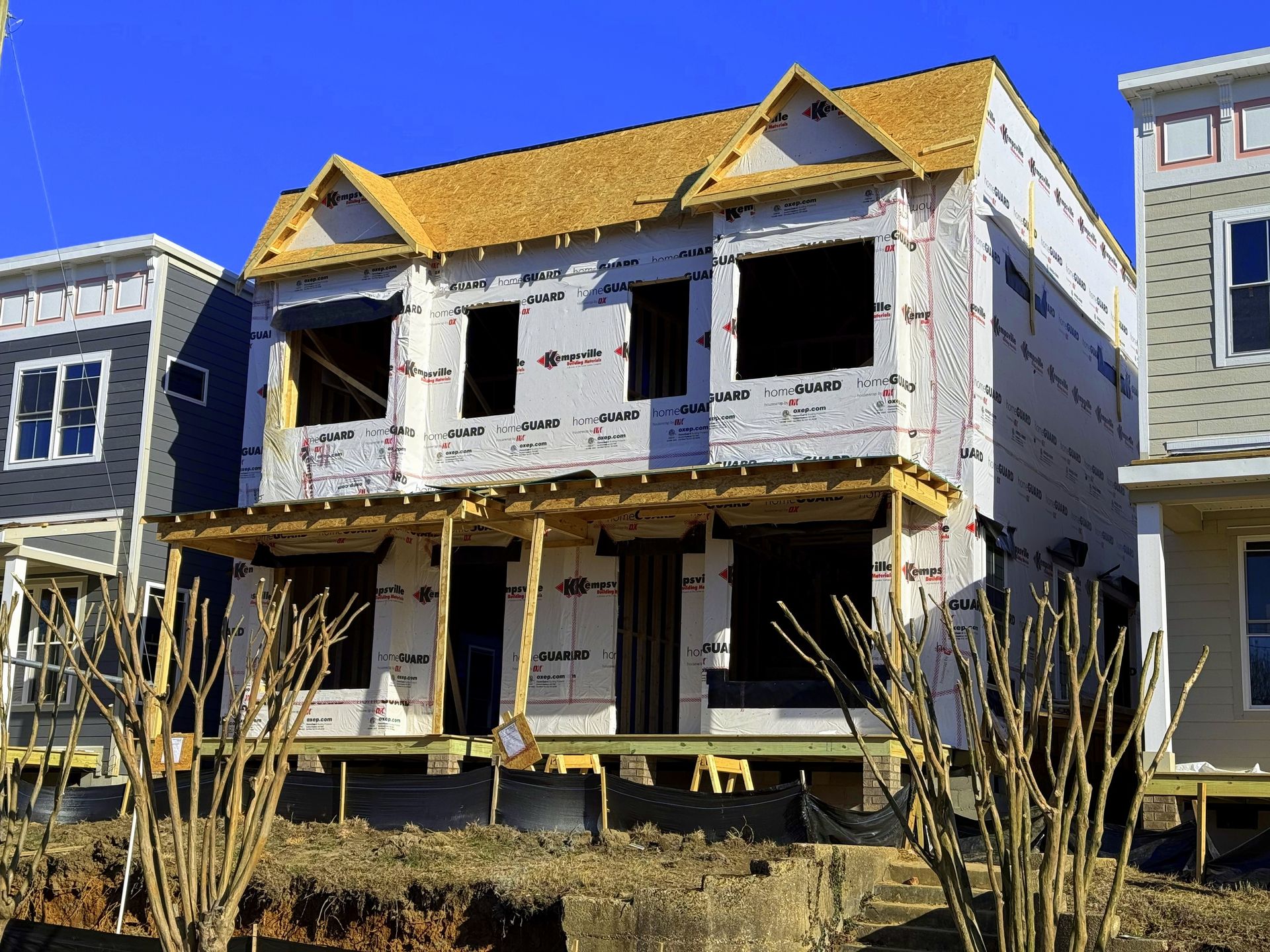 Woman in brown top talking, hands clasped, at a table with a laptop, facing a person holding a tablet.