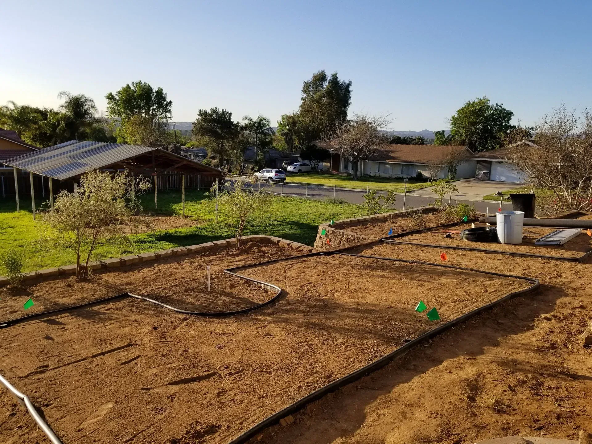 A dirt field with a house in the background.