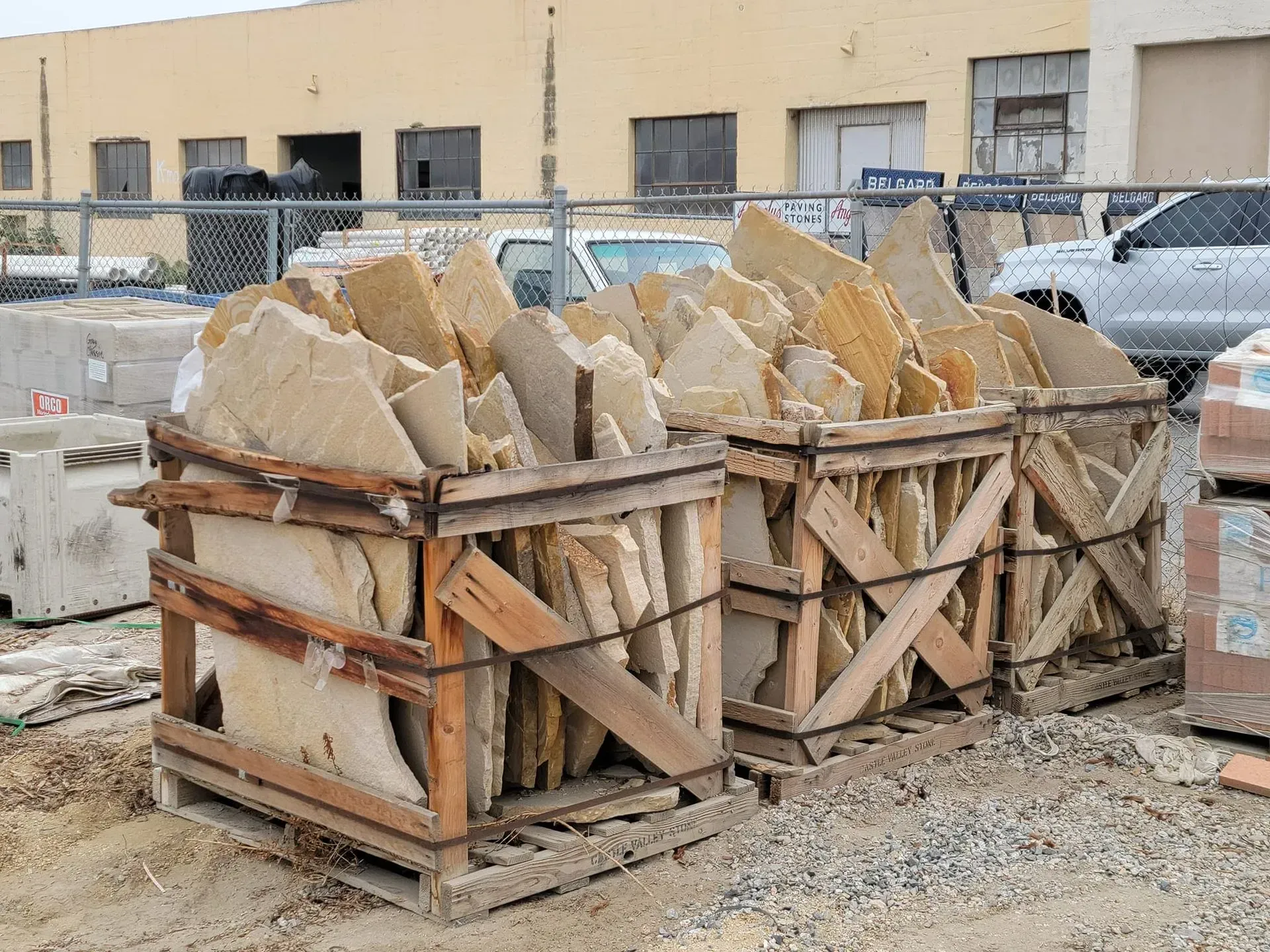 A pile of rocks in wooden crates on a construction site.