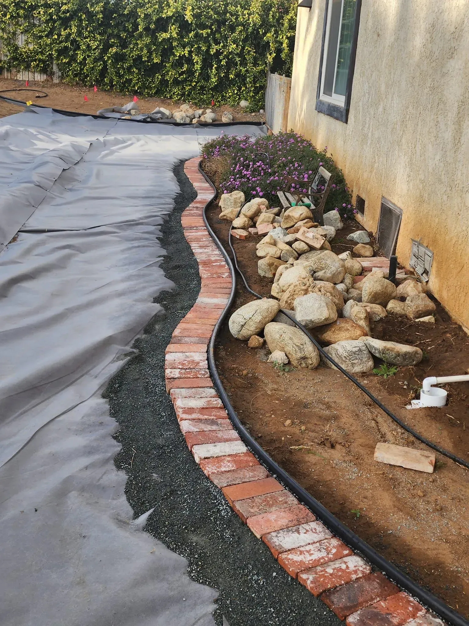 A brick walkway is being built in front of a house.