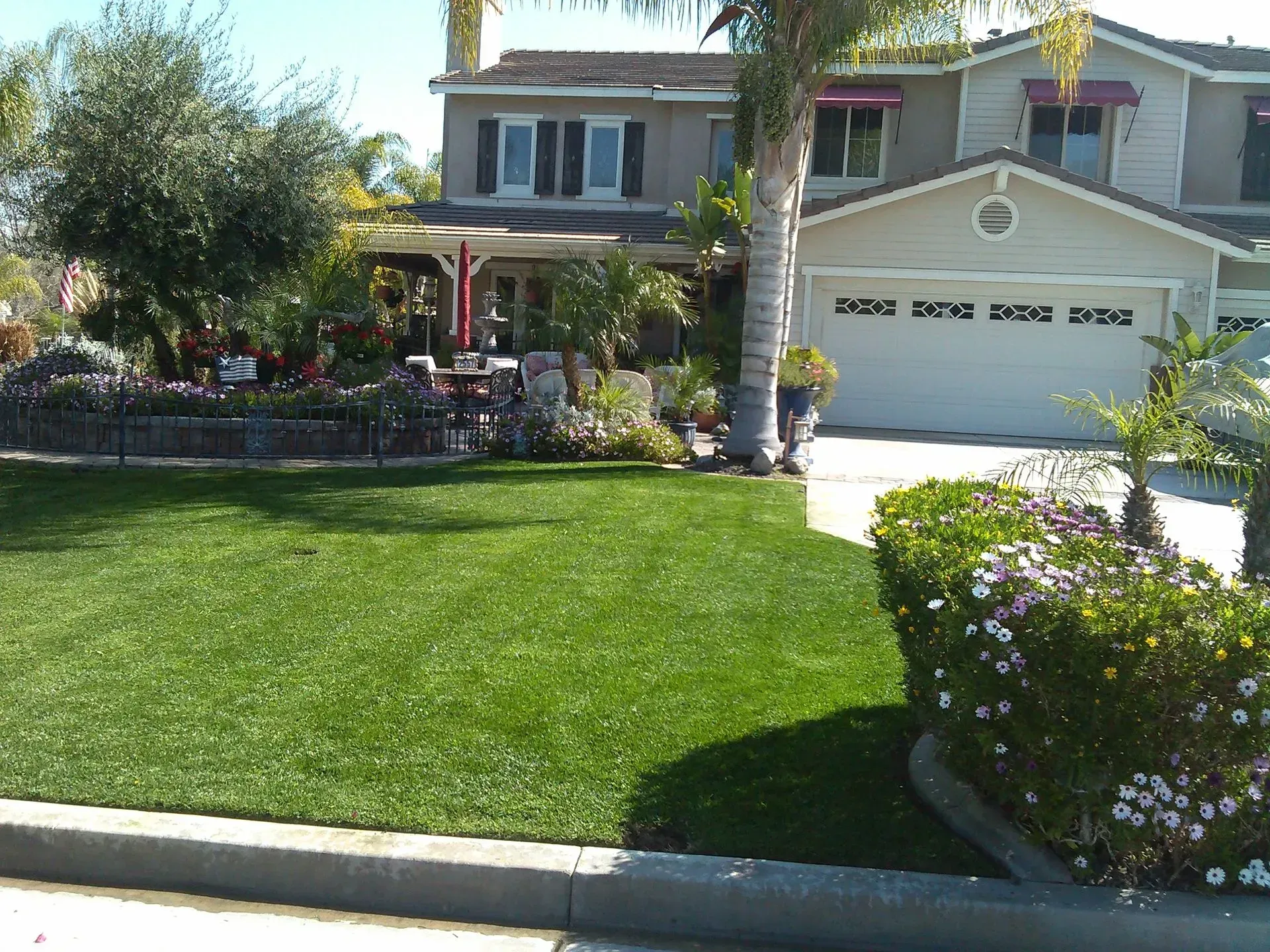 A house with a lush green lawn and a white garage door