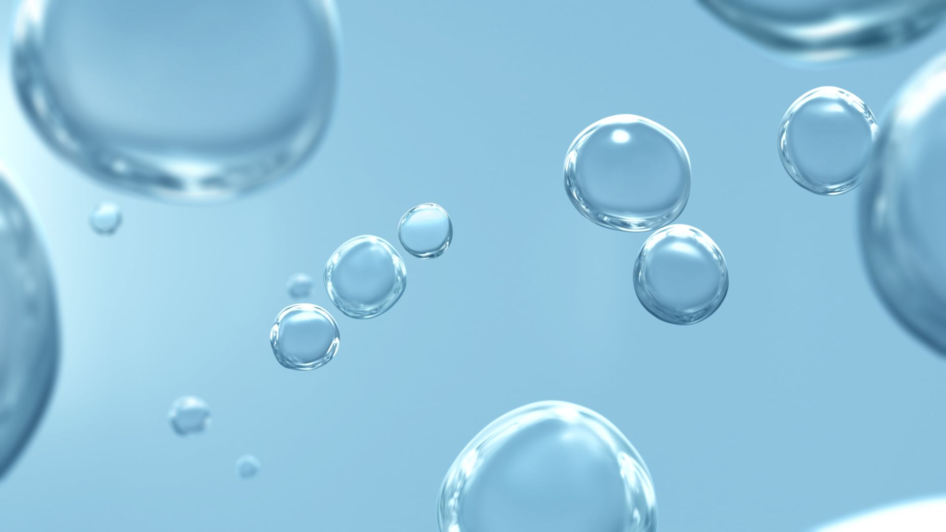Floating translucent water droplets against a light blue background.