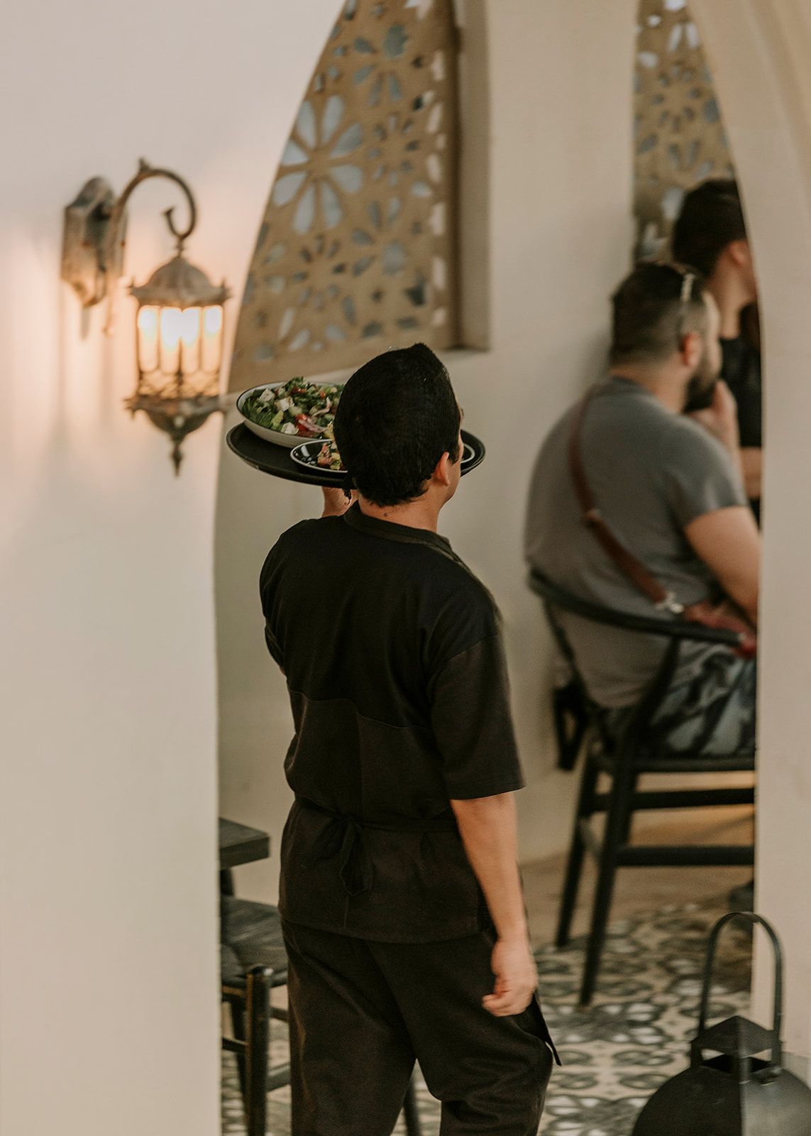 A man wearing a hat is standing in a room with other people.