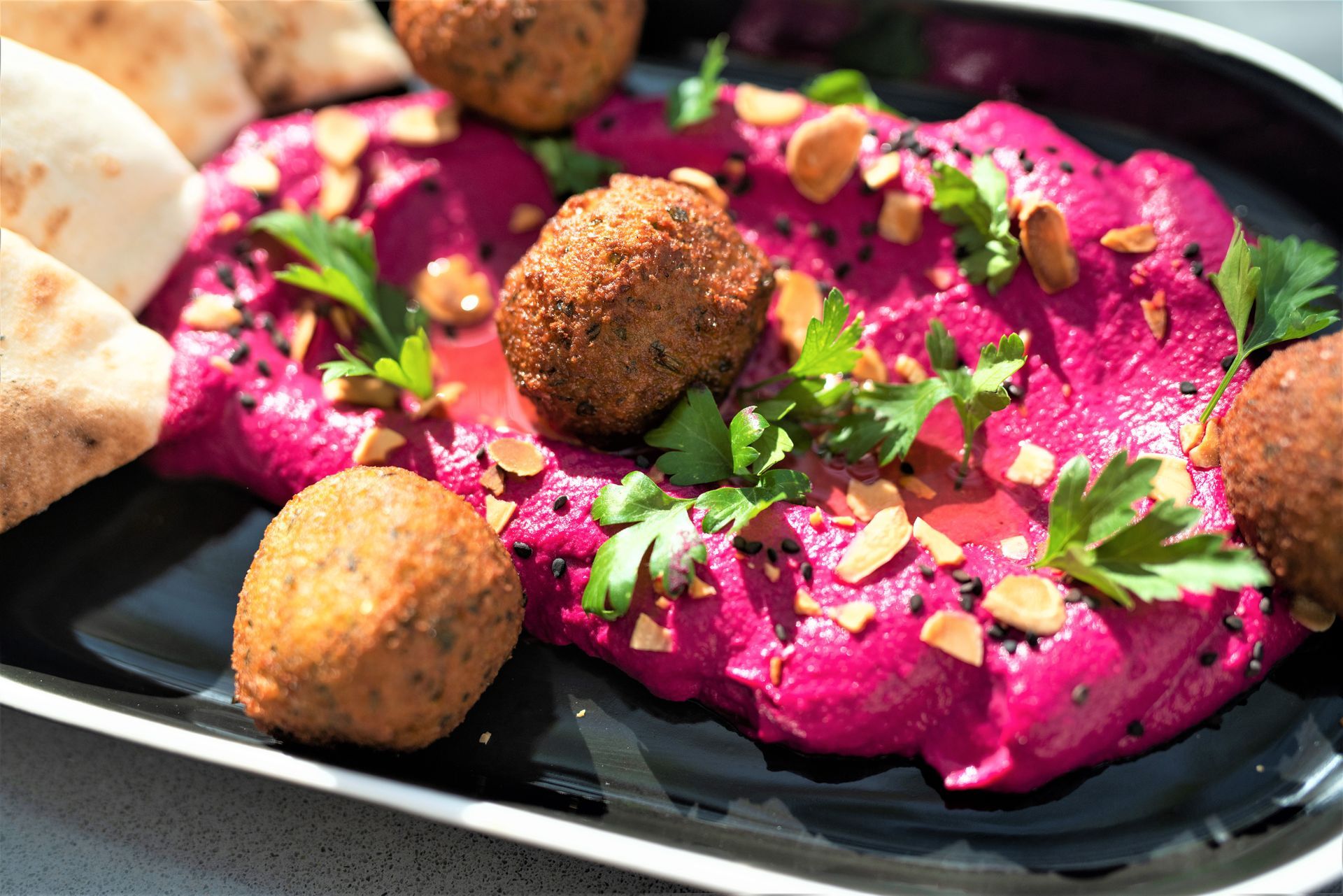 Un plato de comida con hummus y falafel en una mesa.
