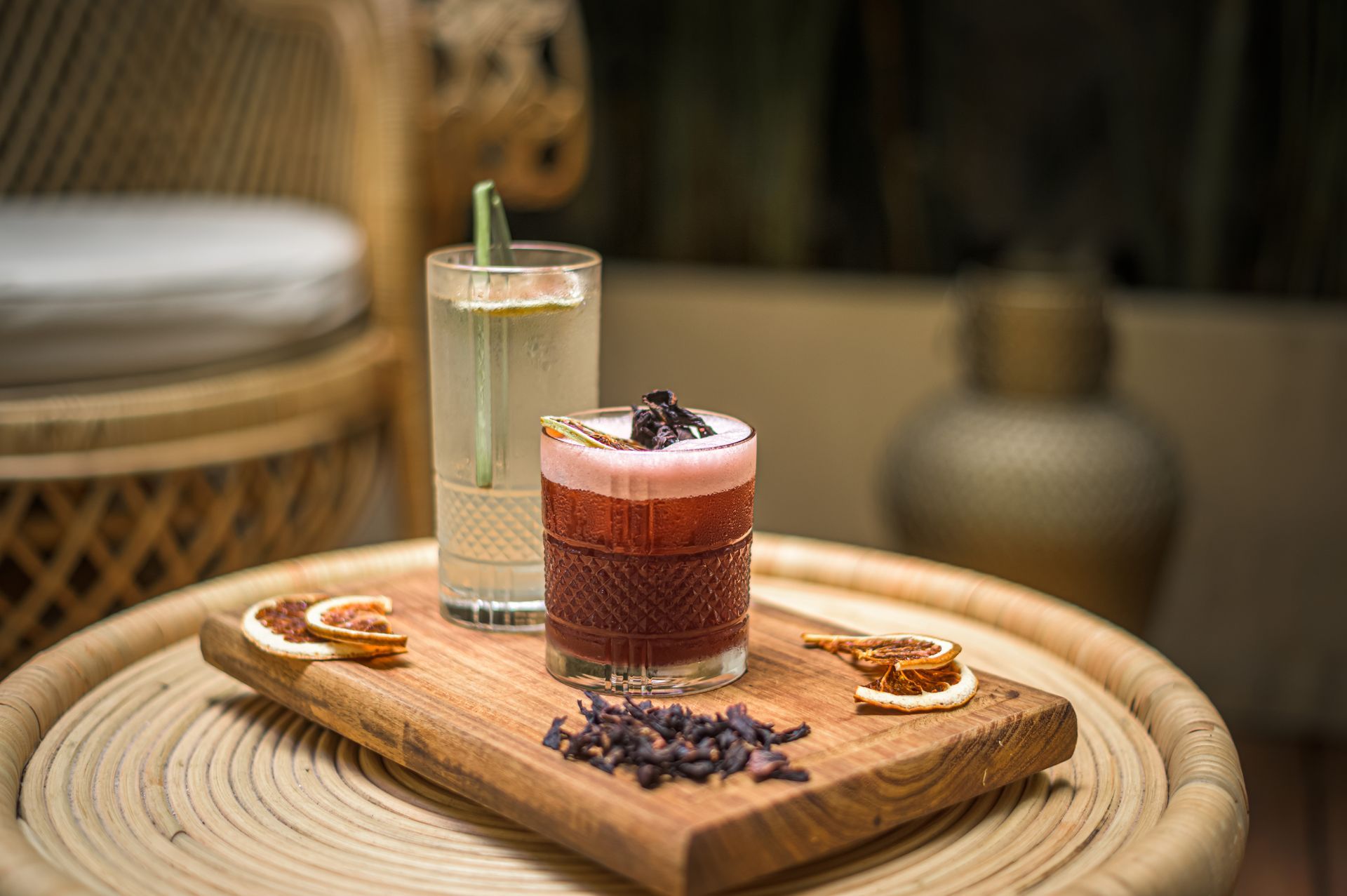 Hay dos bebidas sobre una tabla de cortar de madera sobre una mesa.