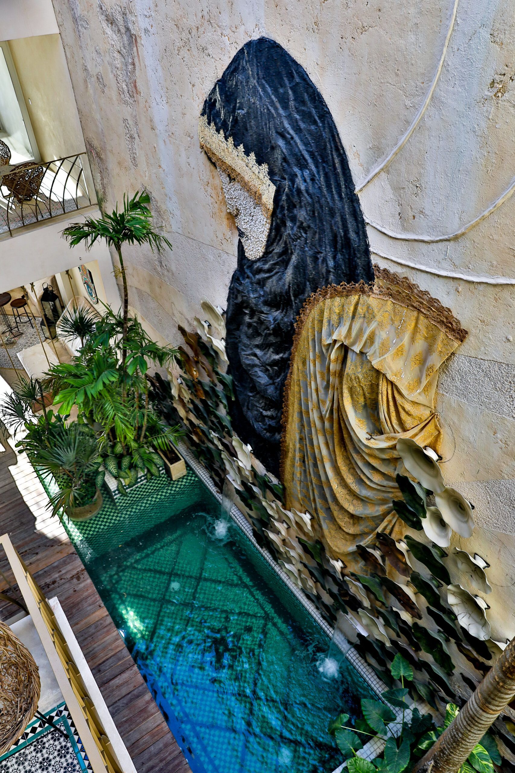 Hay una estatua de una mujer parada junto a una piscina.