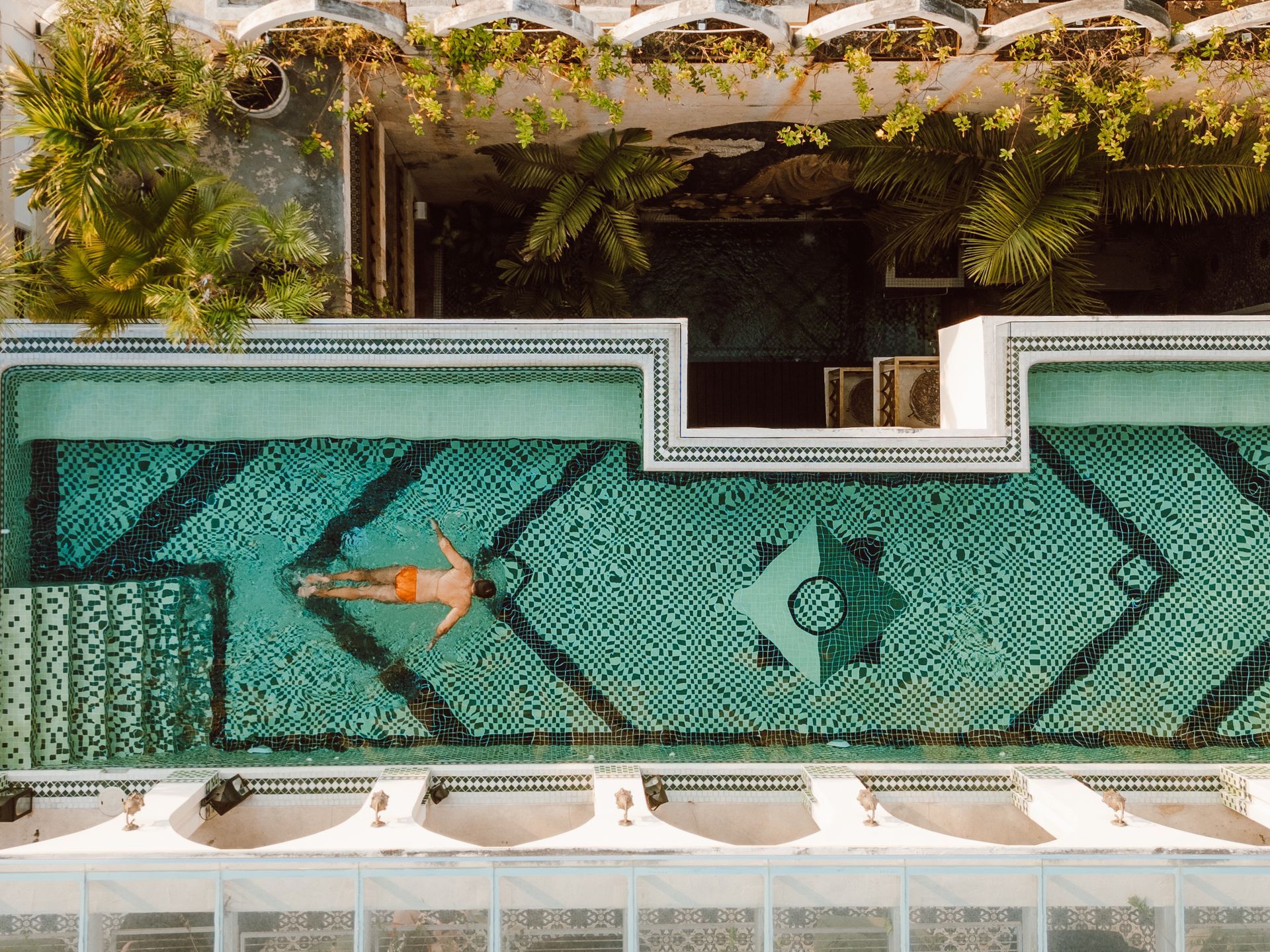 Una vista aérea de un hombre flotando de espaldas en una piscina.