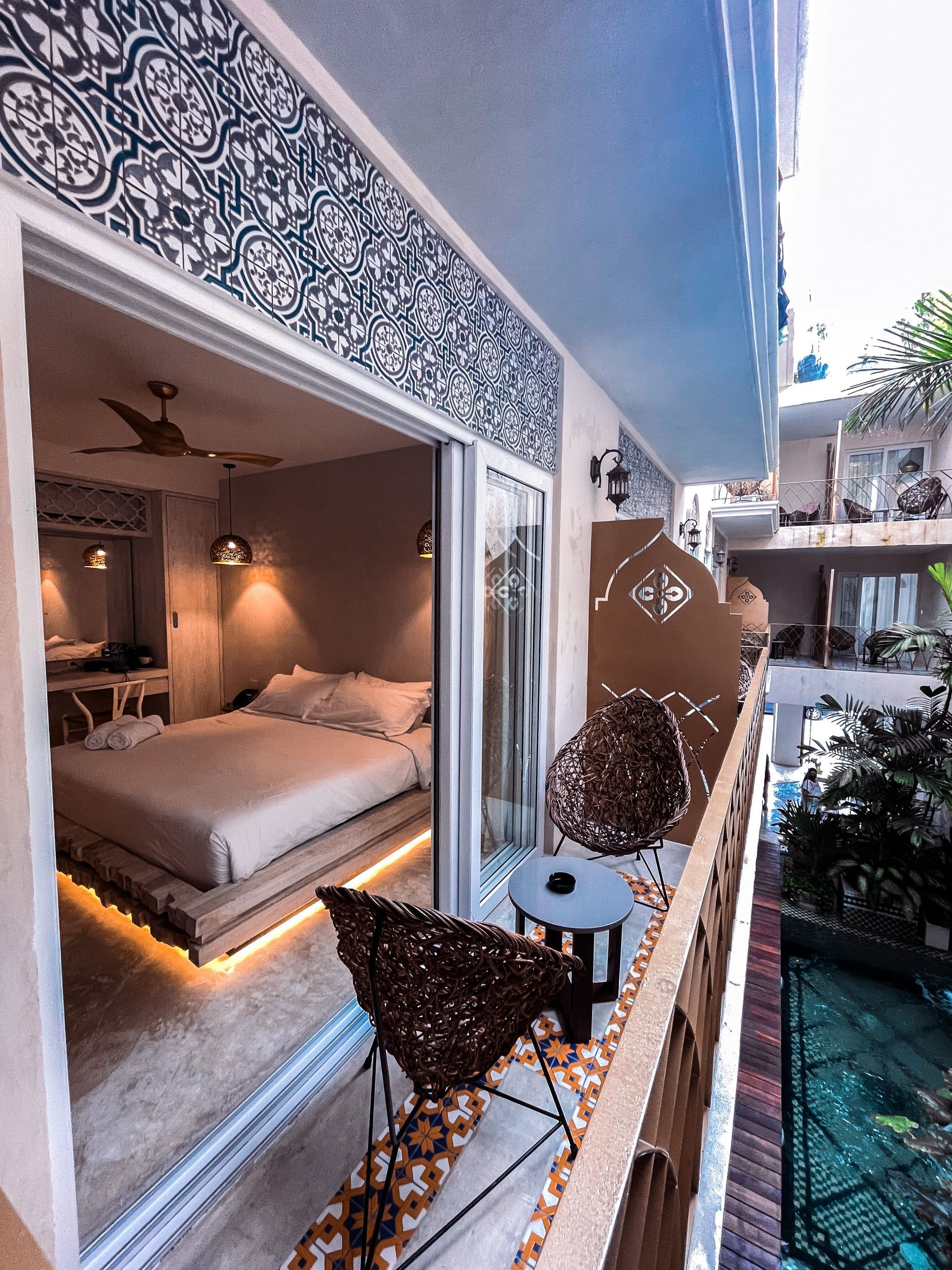 Un balcón con vistas a un dormitorio con cama y sillas.