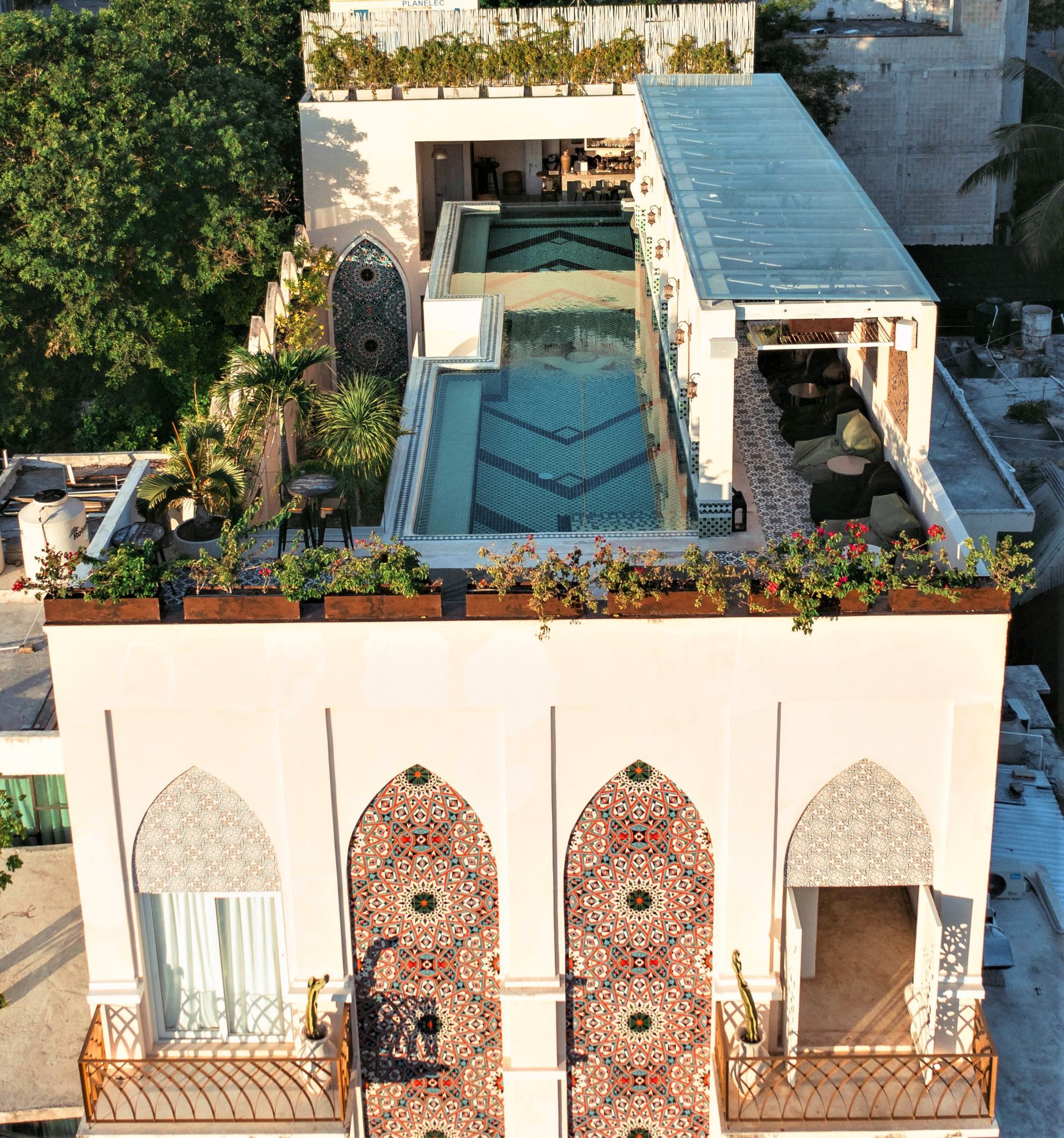 Una vista aérea de un edificio con una piscina en la parte superior.