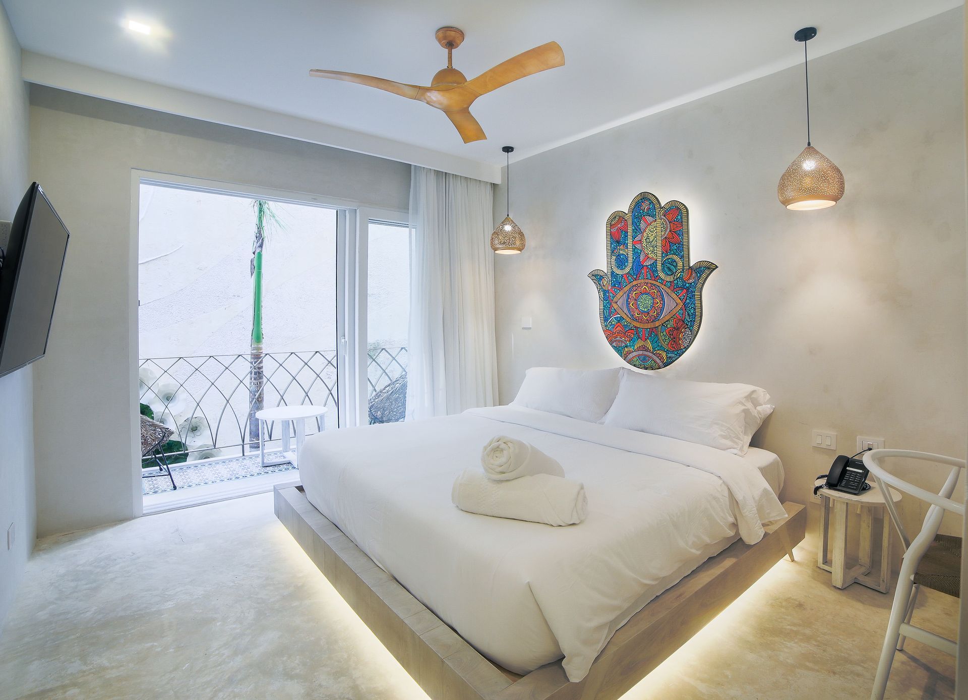 Un dormitorio con una cama grande y un ventilador de techo.