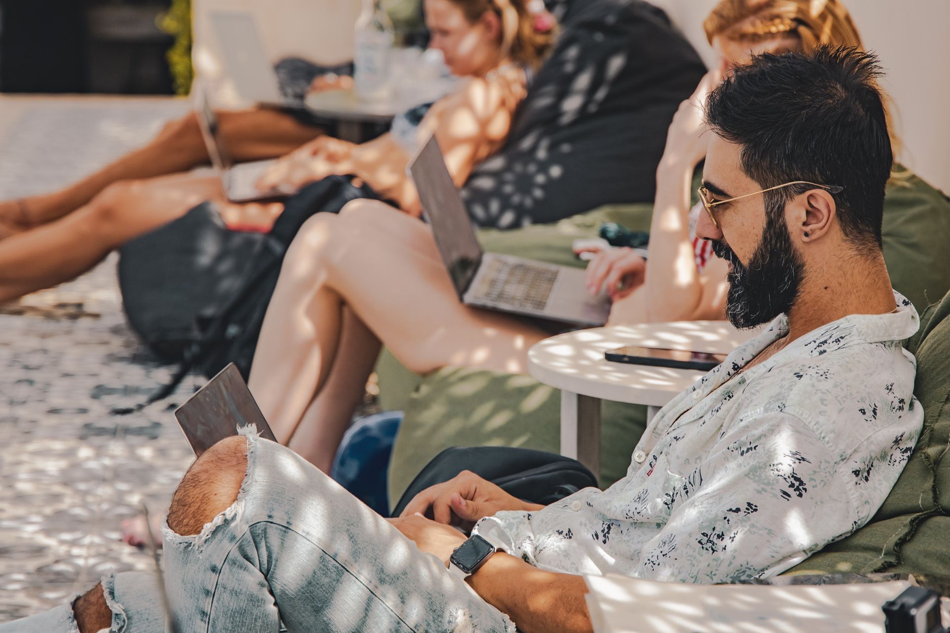 Un hombre está sentado en una silla utilizando una computadora portátil.