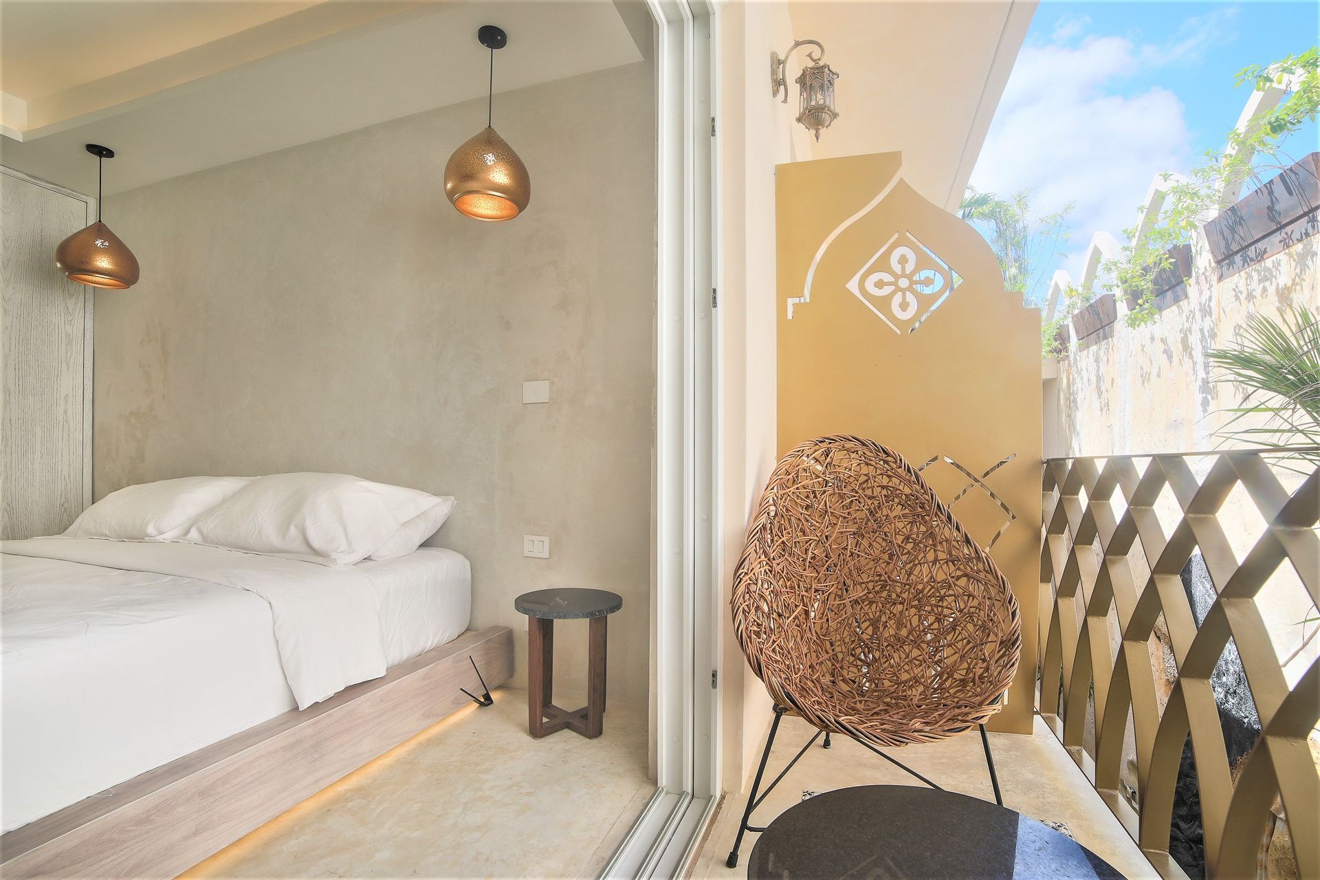 Un dormitorio con una cama y una silla en un balcón.