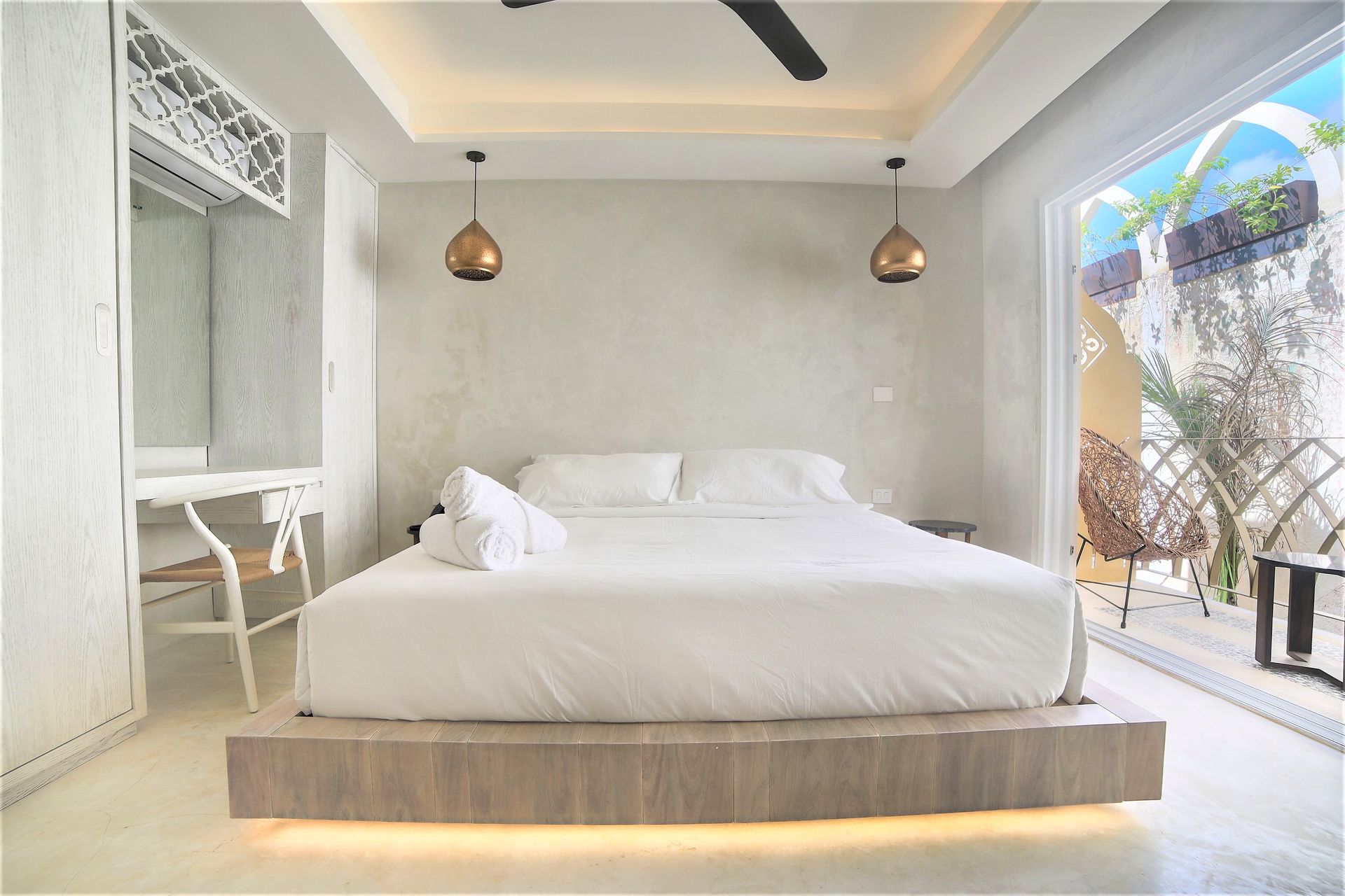 Un dormitorio con una cama grande y un ventilador de techo.