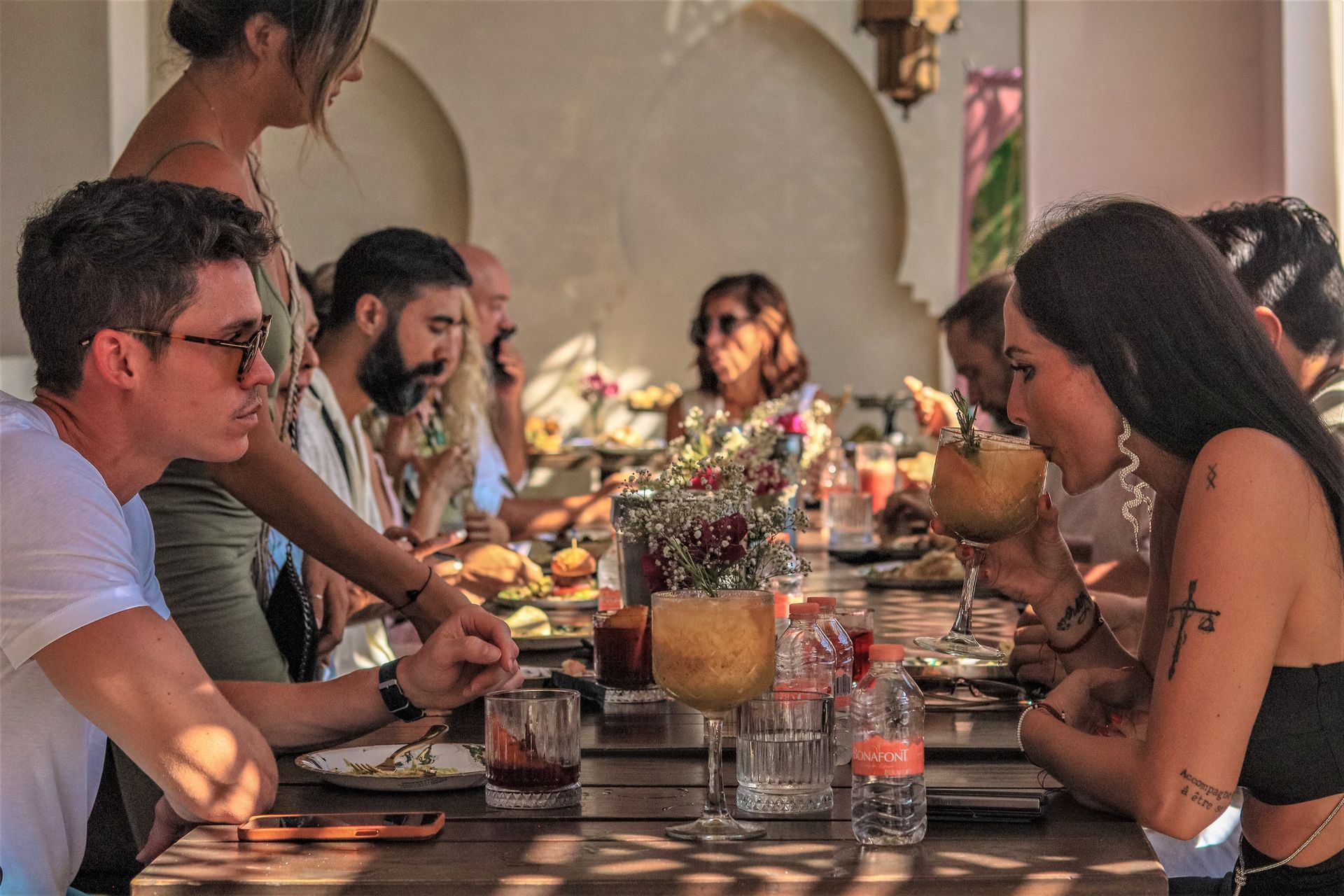 A group of people are sitting at a long table eating food.
