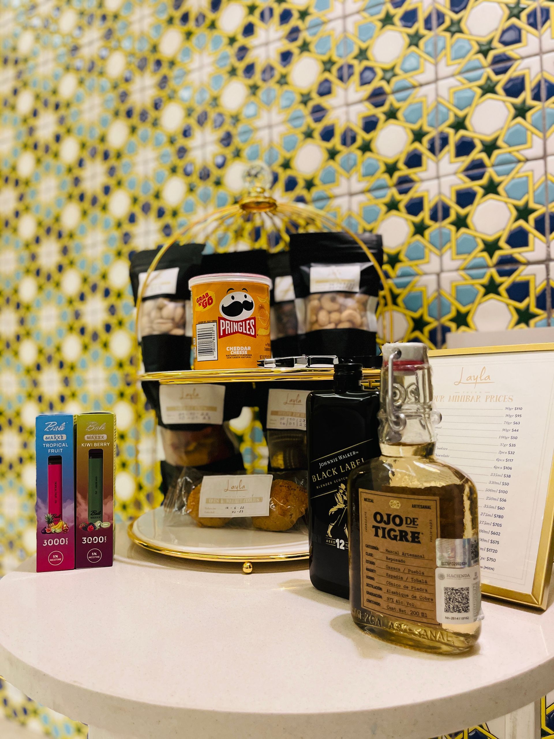 Una mesa con botellas de licor y bocadillos encima.