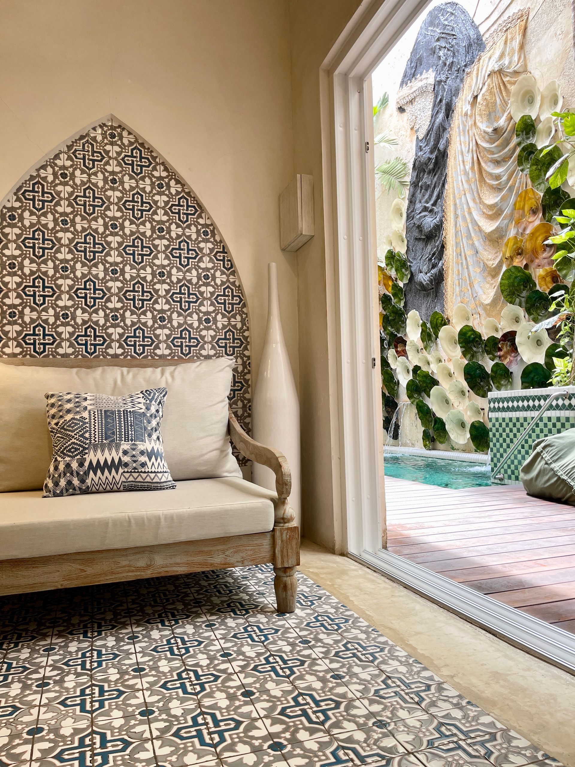 Una sala de estar con un sofá y una alfombra y vista a una piscina.