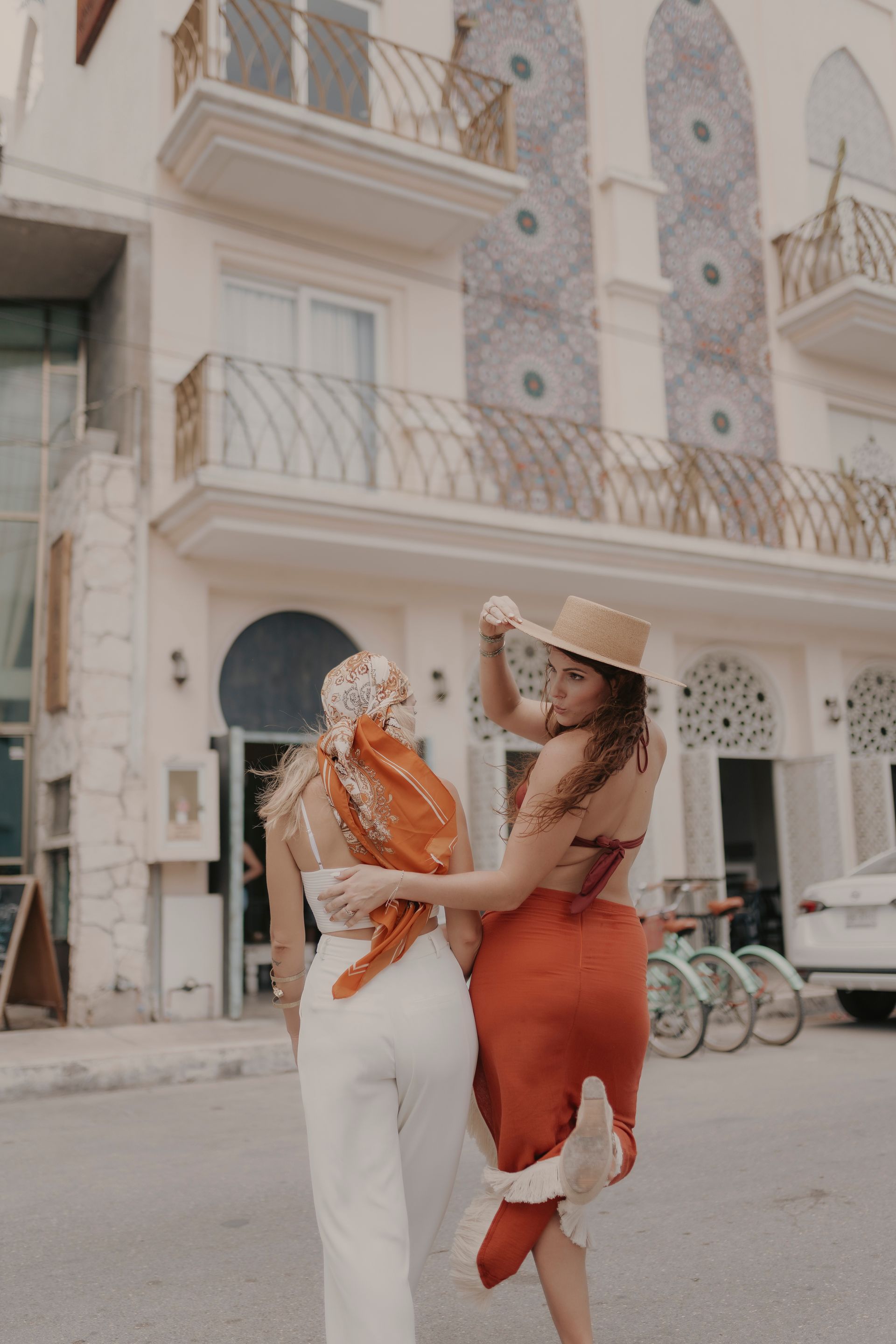 Dos mujeres están paradas una al lado de la otra frente a un edificio.