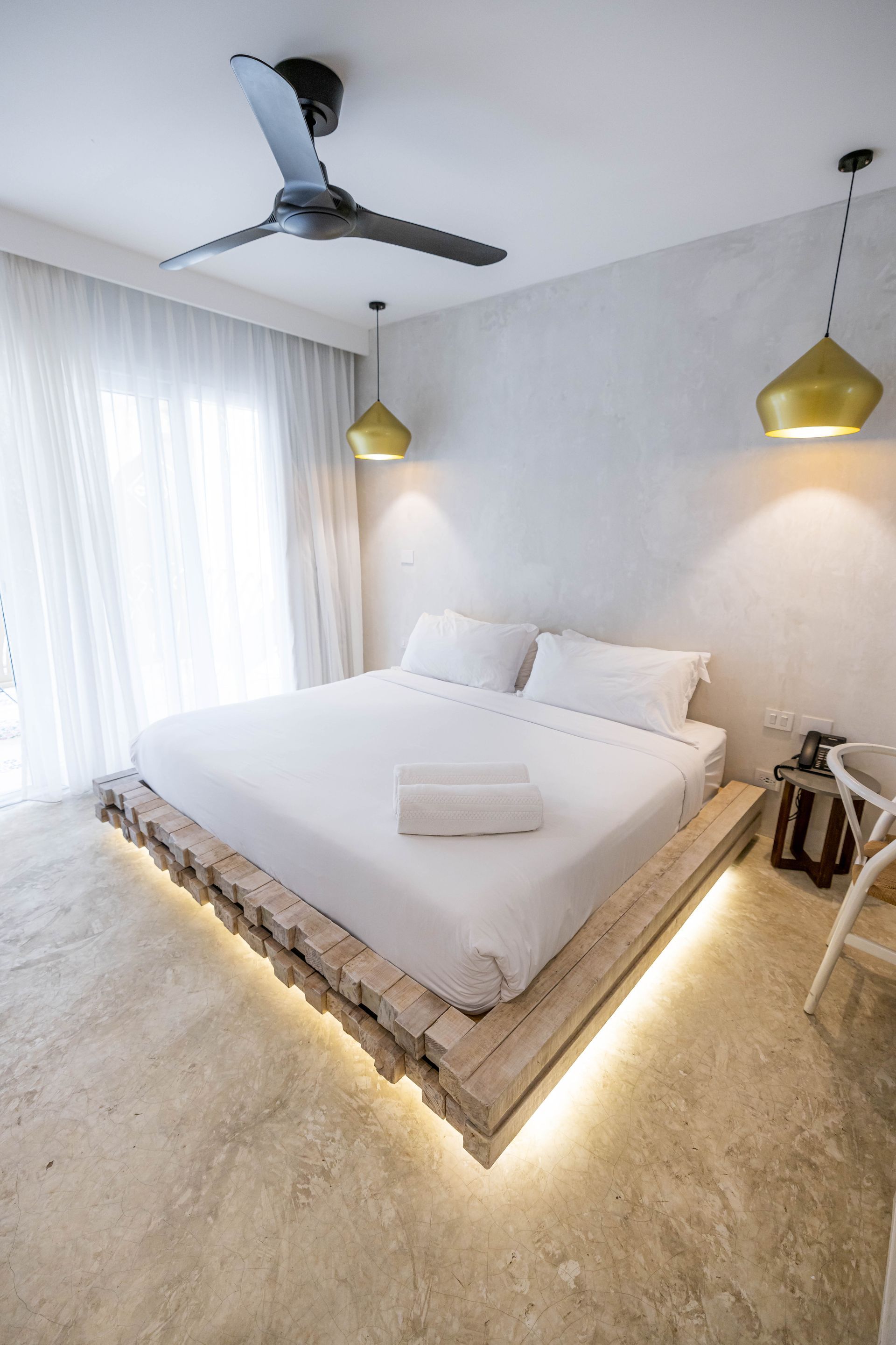 Un dormitorio con una cama y un ventilador de techo.