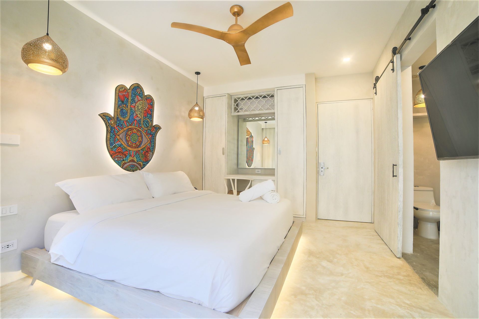 Un dormitorio con una cama grande y un ventilador de techo.