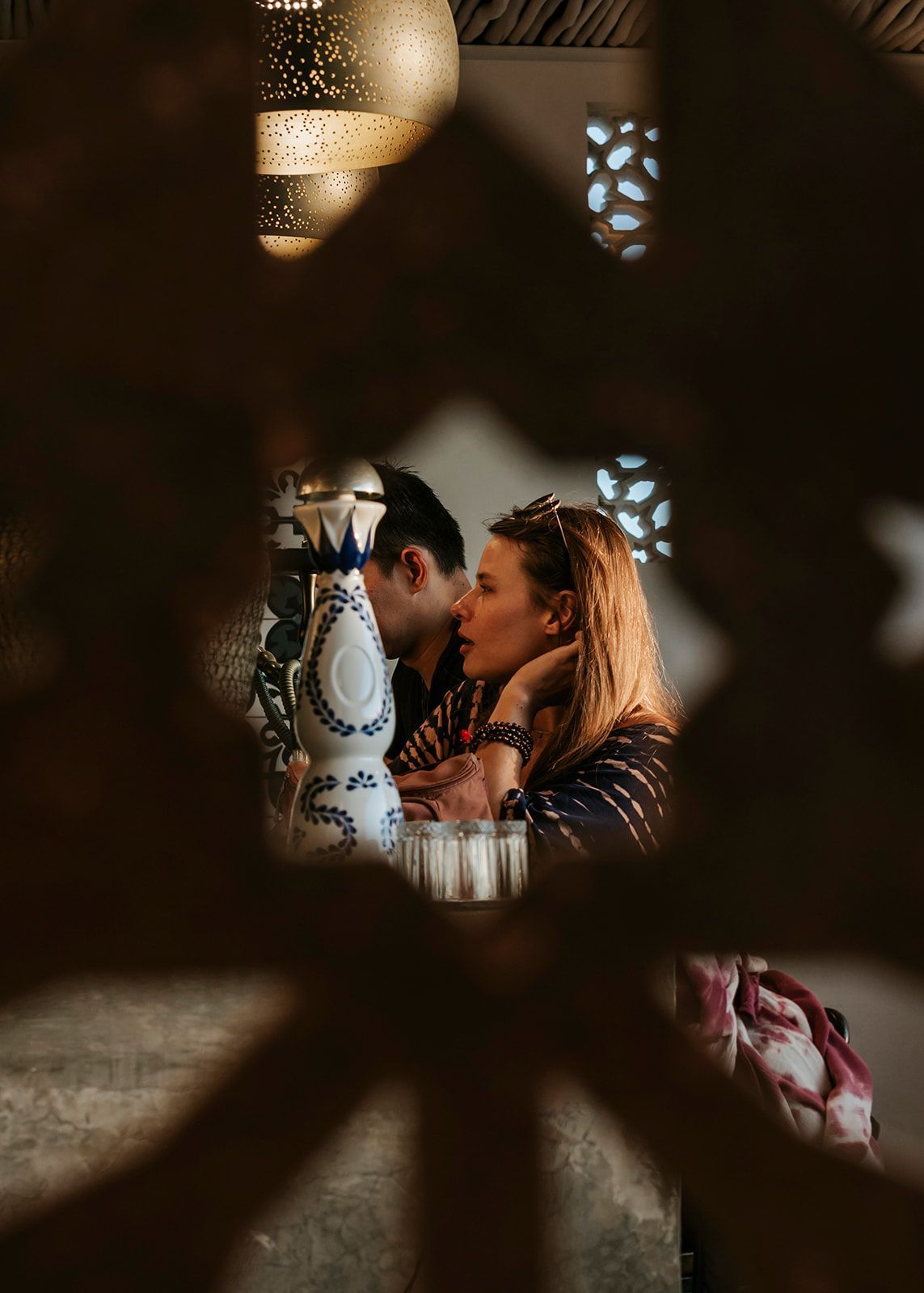 A man and a woman are sitting at a table and kissing.