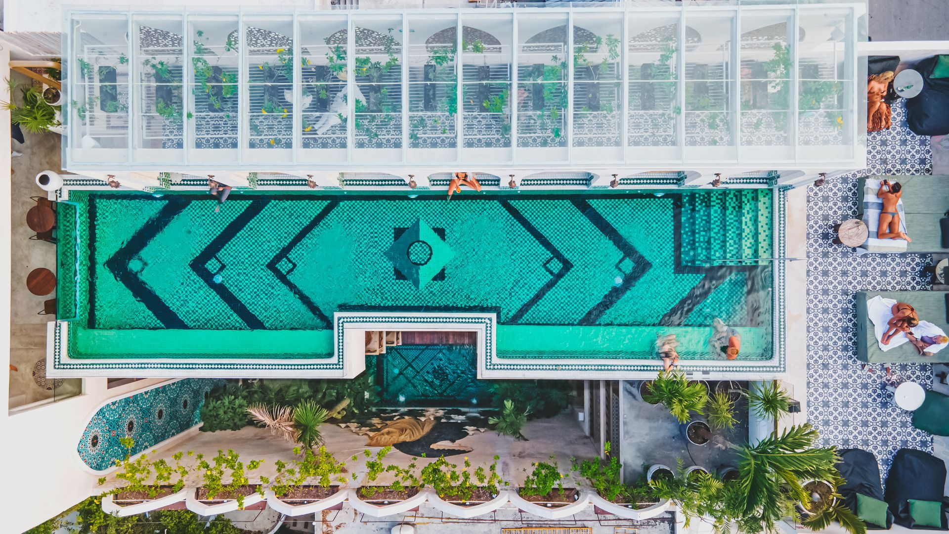 An aerial view of a large swimming pool with people swimming in it.