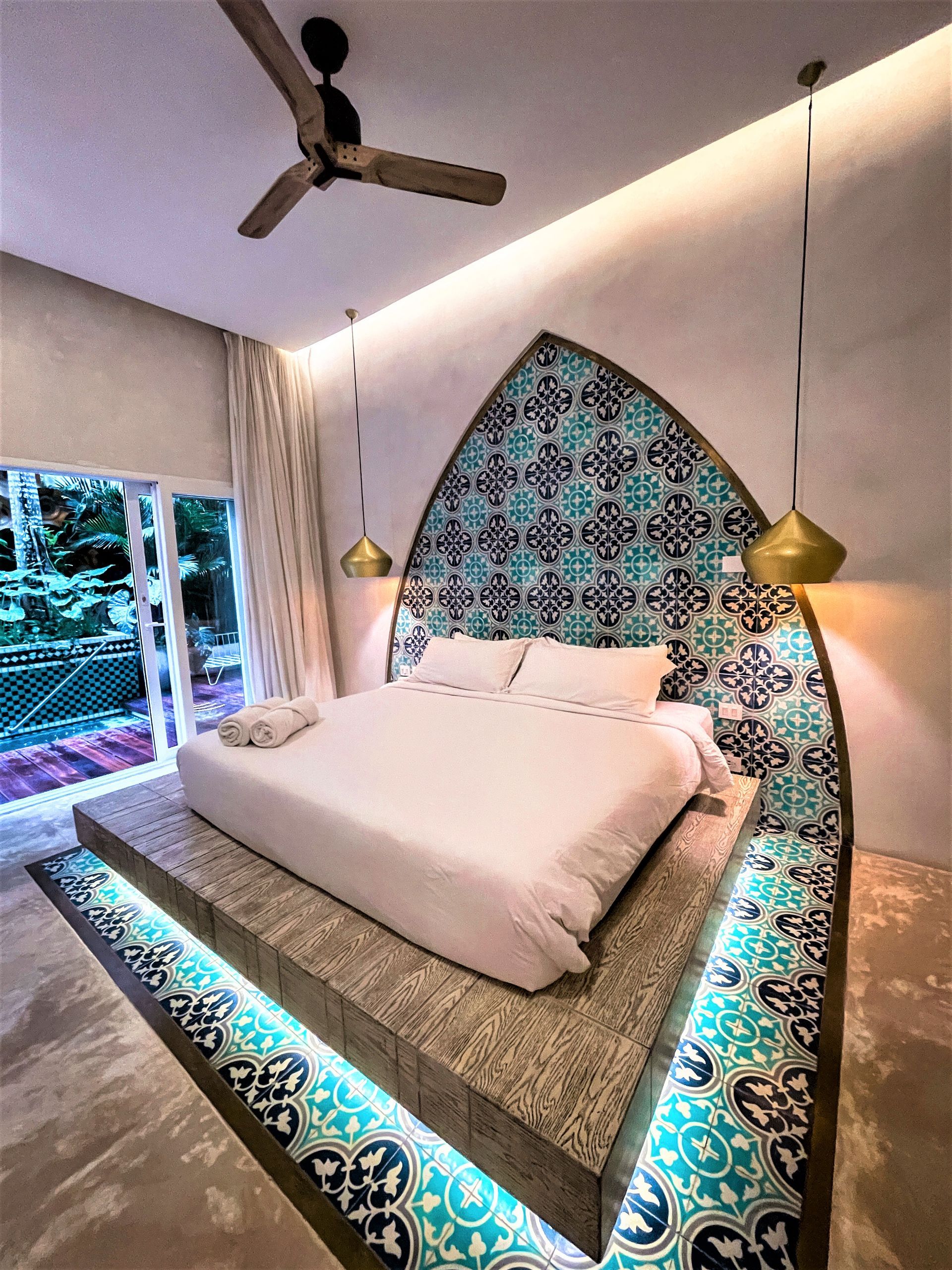 Un dormitorio con una cama grande y un ventilador de techo.