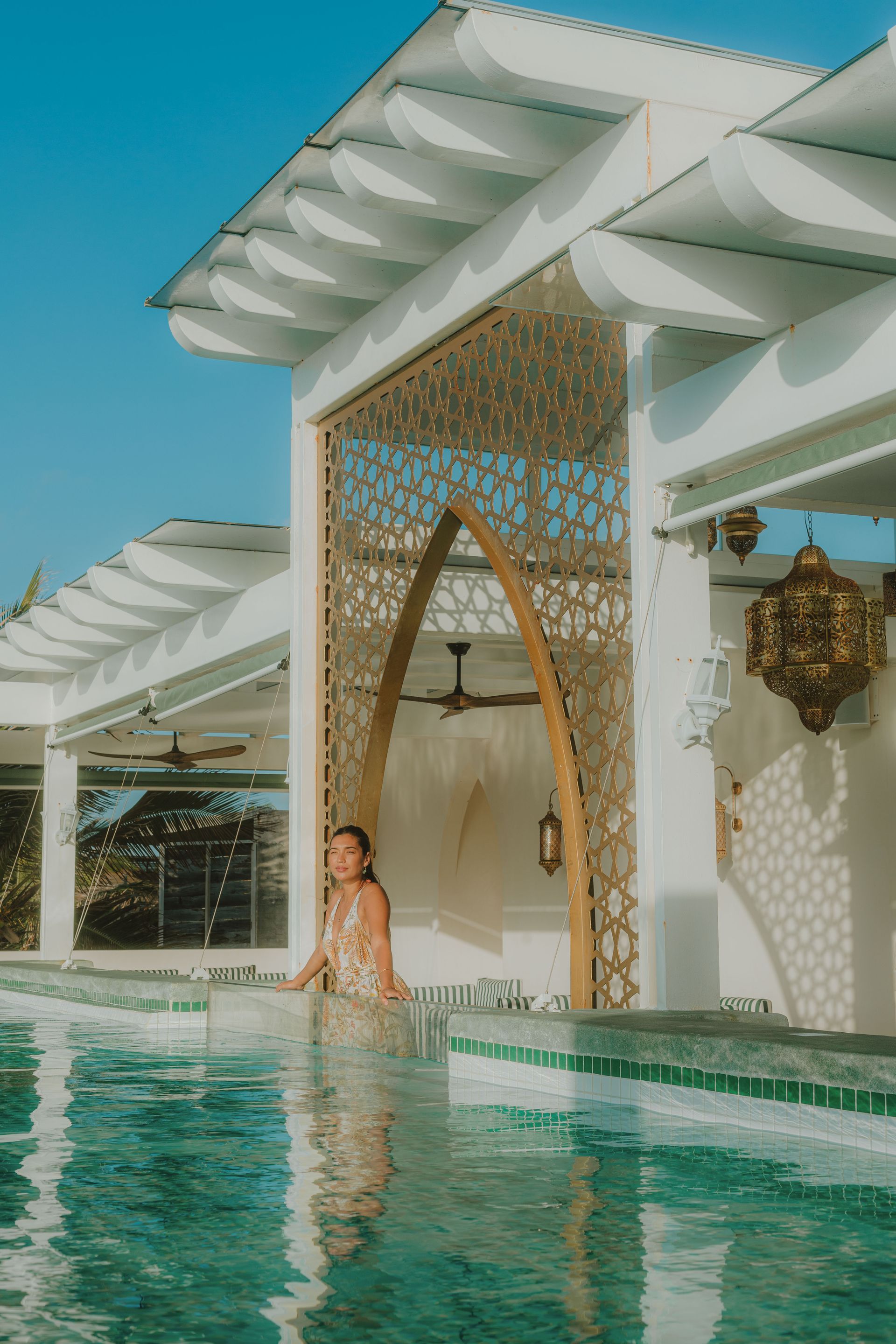 a woman is standing by the rooftop pool at sana Tulum beachfront boutique hotel where she has a sea view to the caribbean sea