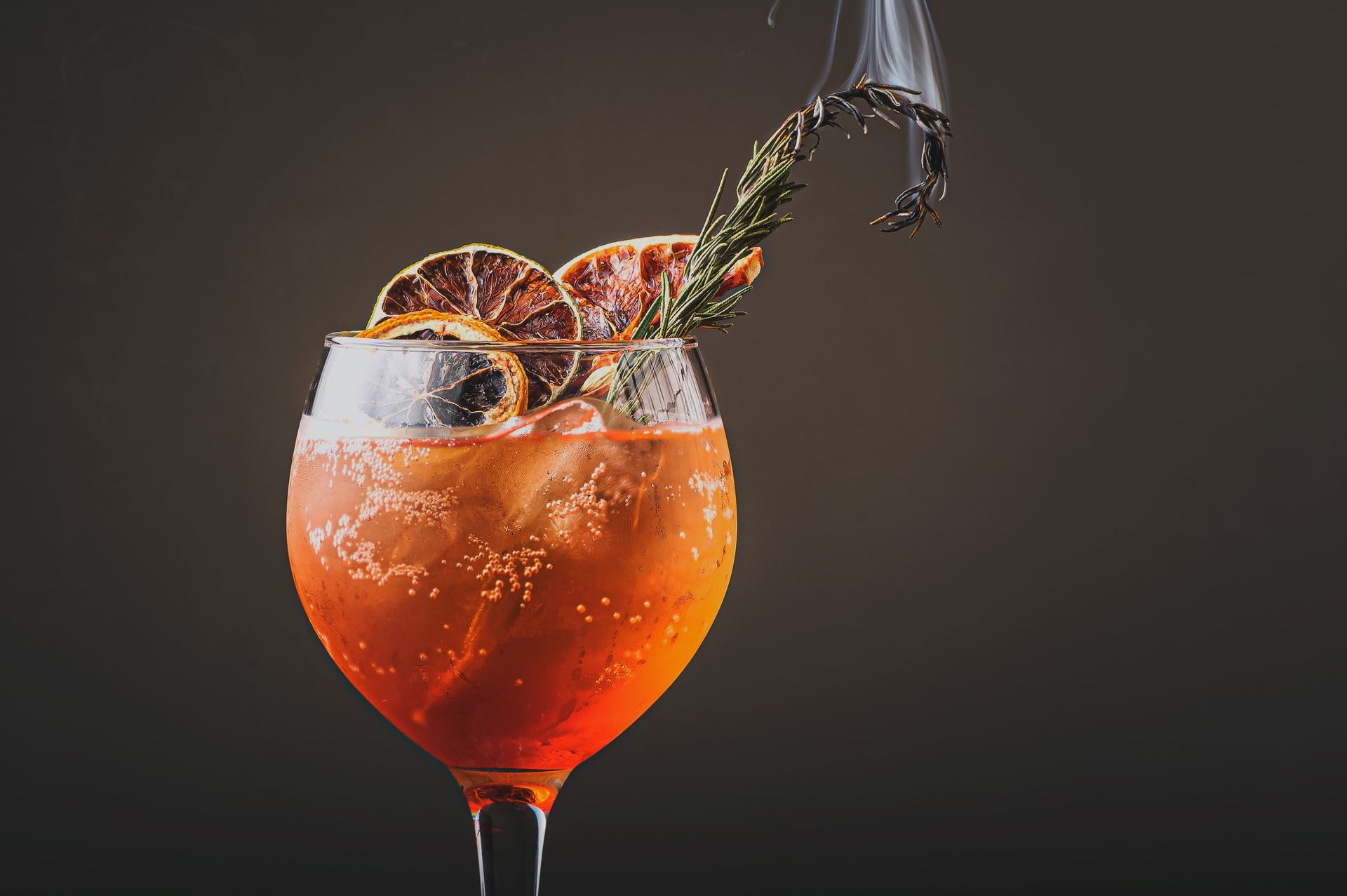 Un primer plano de una bebida en una copa de vino de la que sale un chorrito.