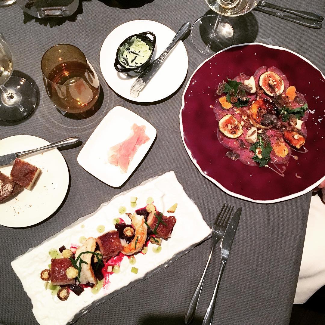 Ein Tisch mit Tellern voller Essen und Weingläsern