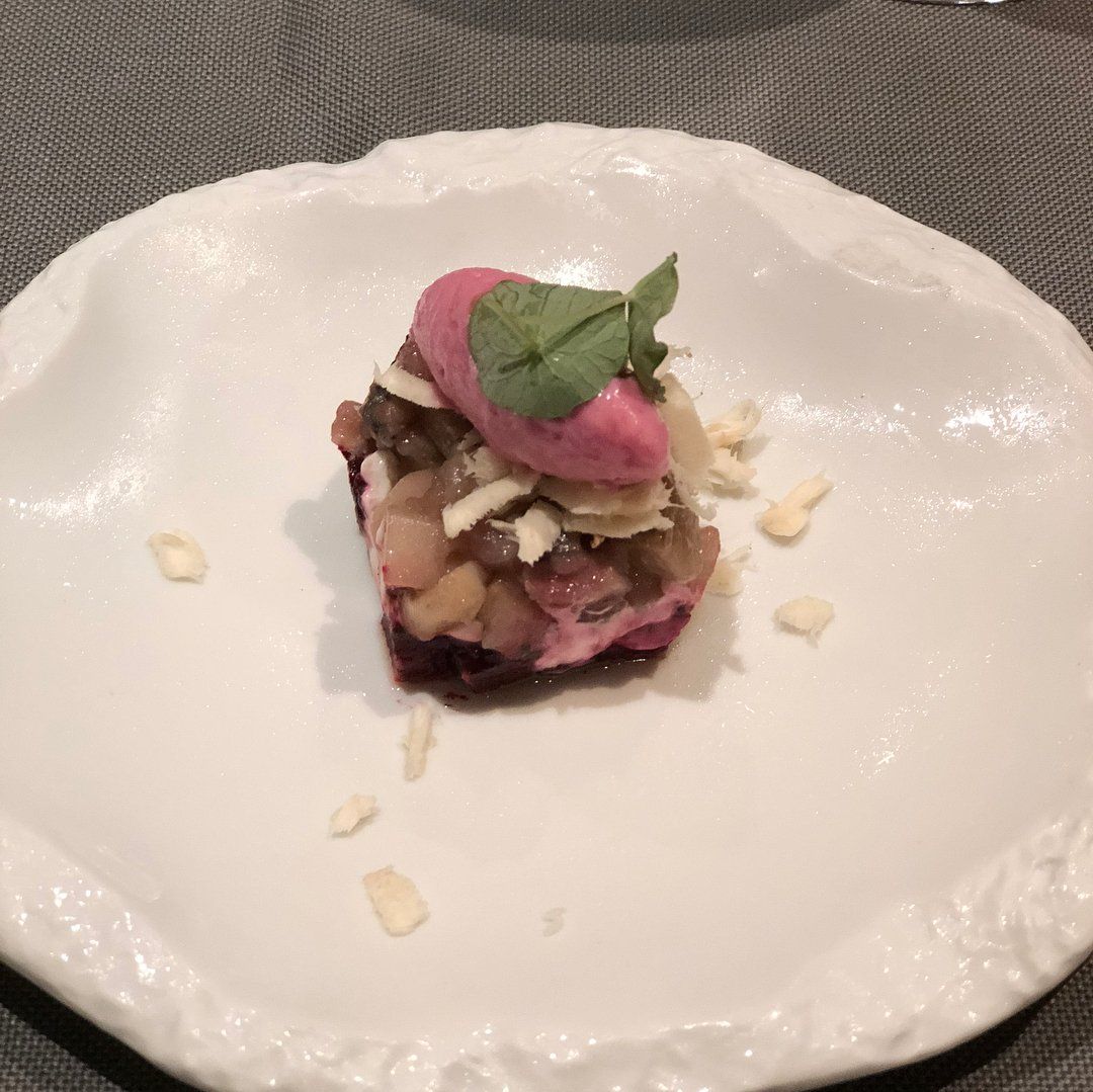 Ein weißer Teller mit einem Stück Essen auf einem Tisch.