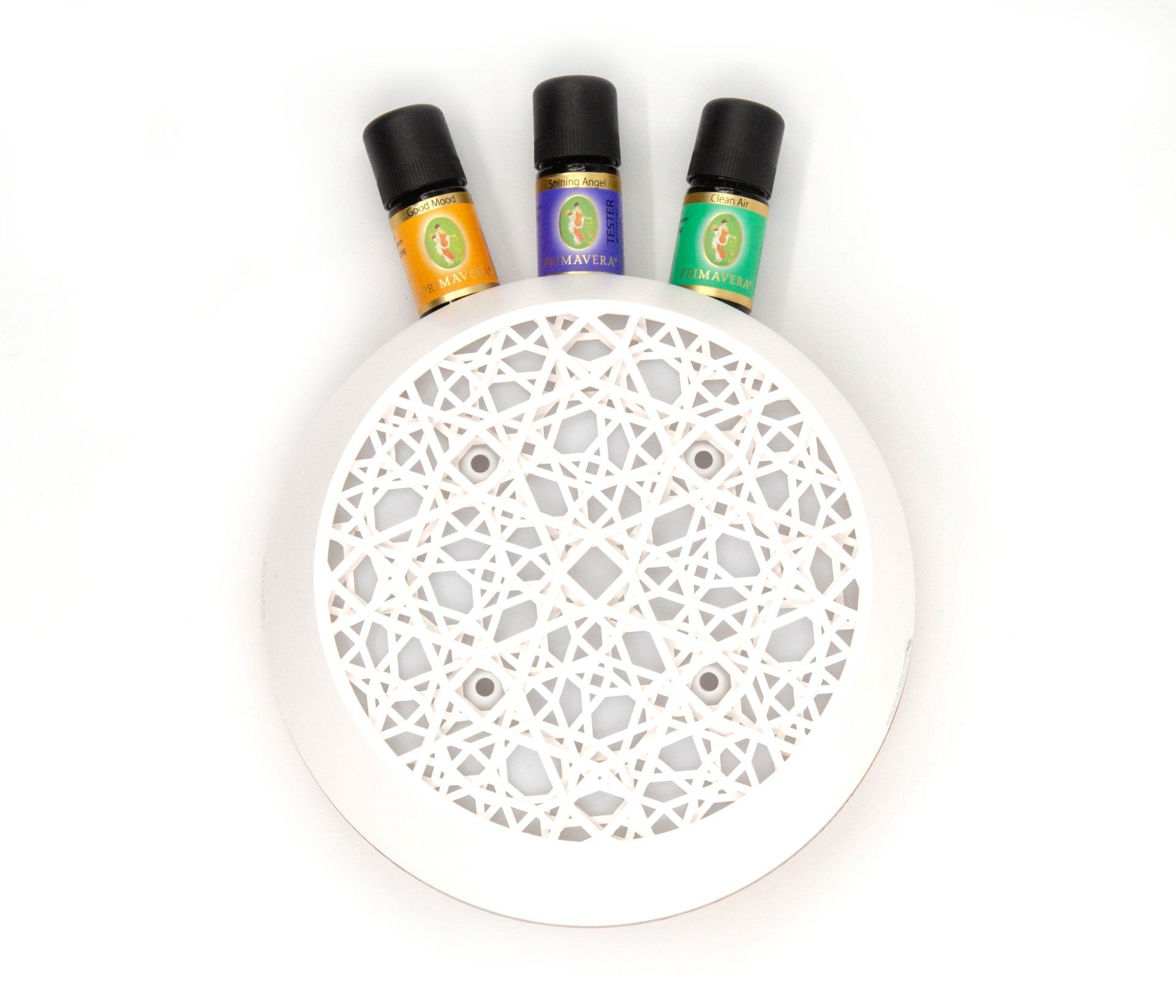 Tre flasker med eteriske oljer sitter på toppen av en hvit tallerken.