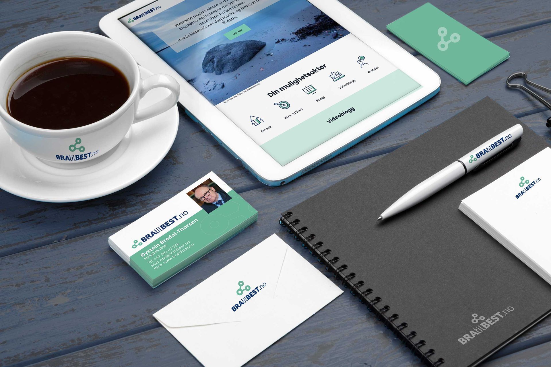 Et nettbrett sitter på et bord ved siden av en kopp kaffe