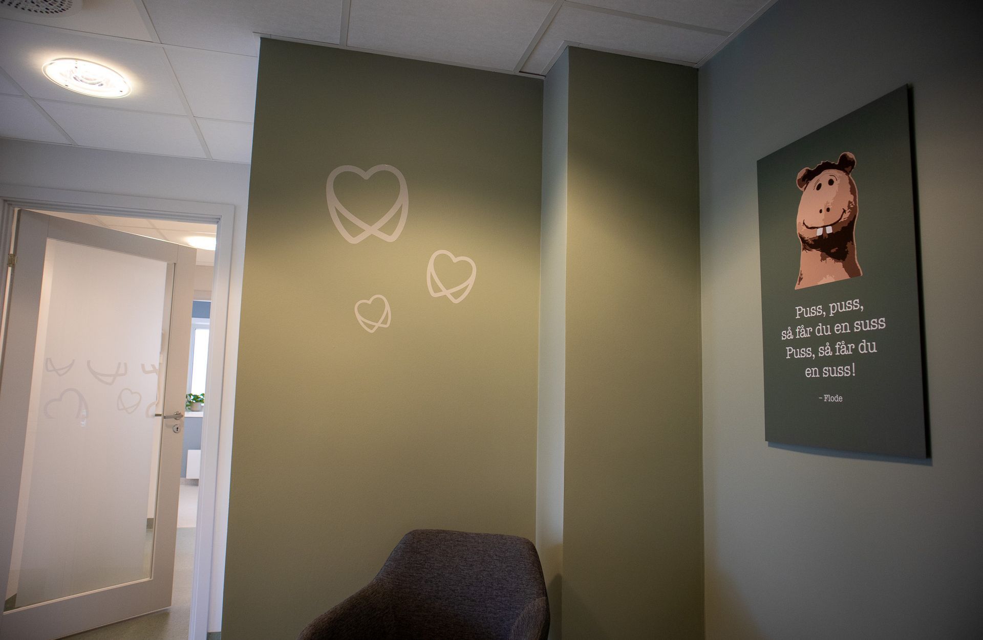 Et rom med en stol og et bilde på veggen