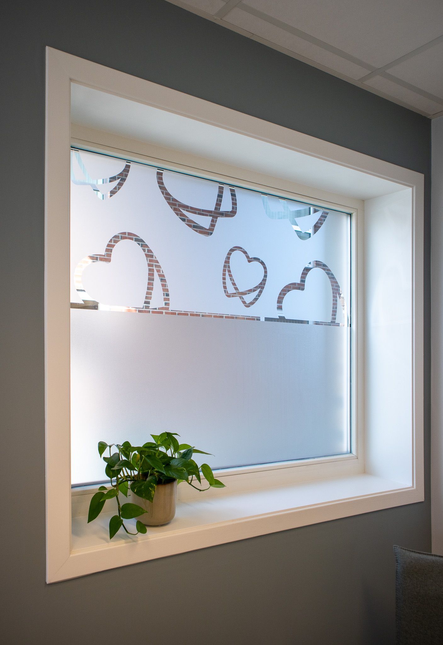 Et vindu med en potteplante foran