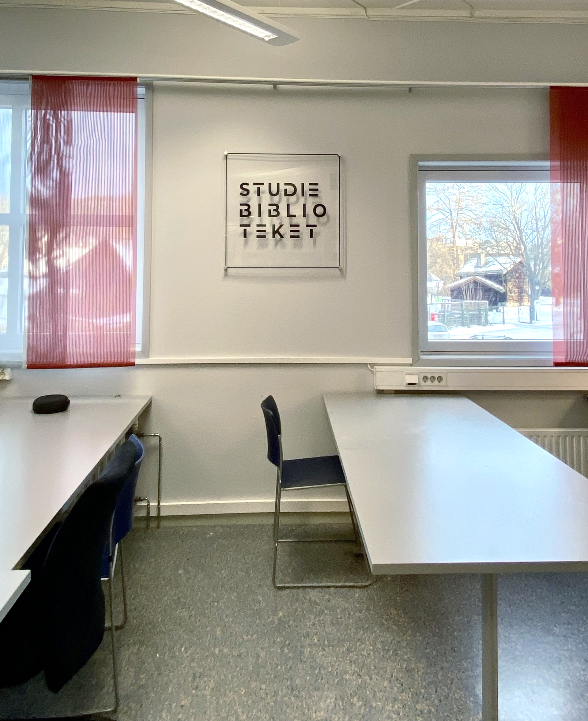 Et rom med et skilt på veggen som sier studiebiblioteket