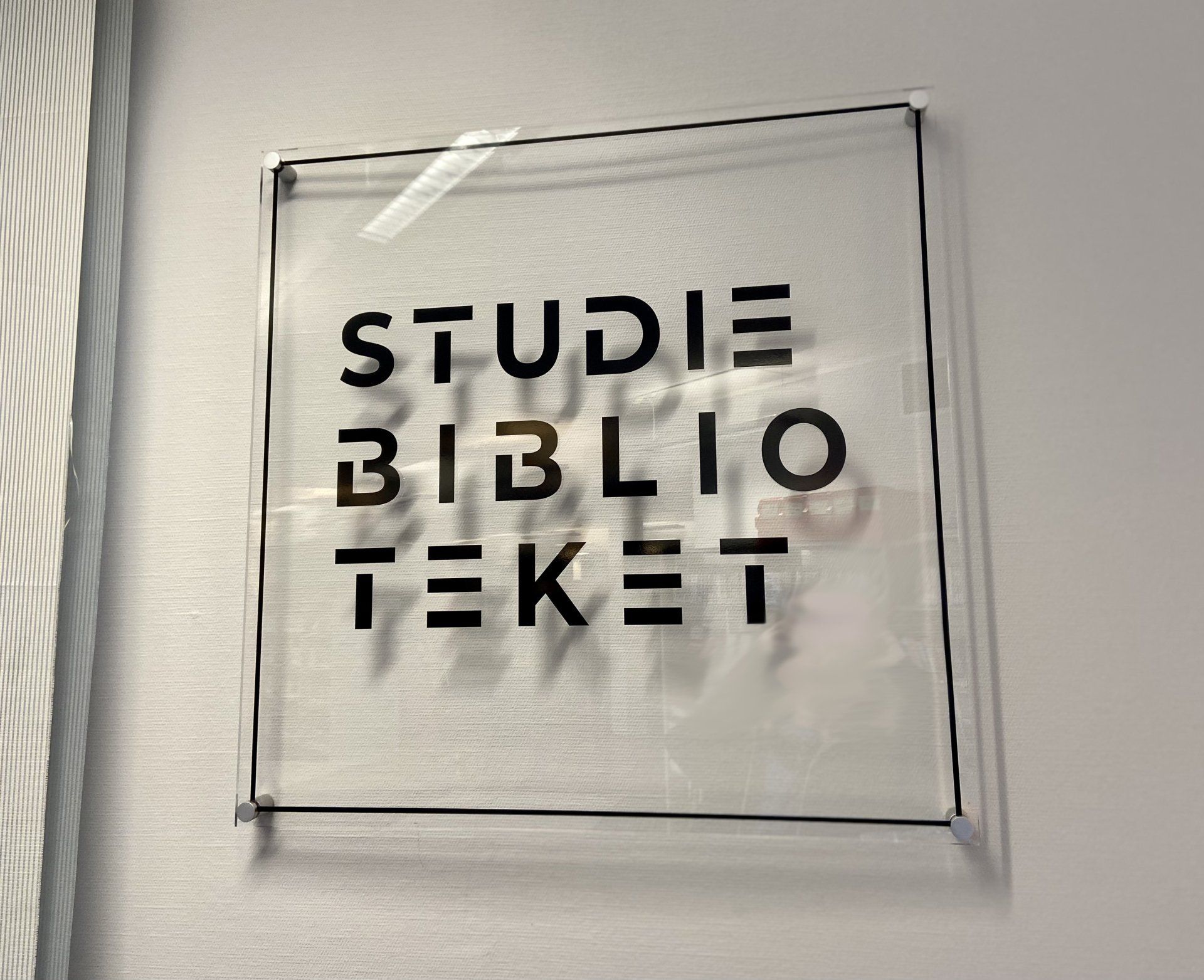Et skilt på en vegg som sier studie biblio teket