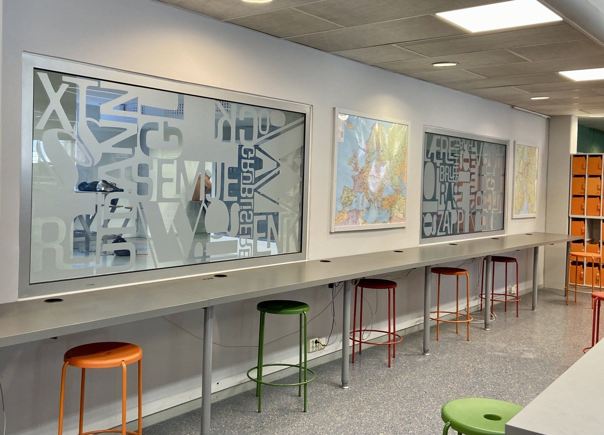 En rad med bord og krakker i et rom med et vindusdekor