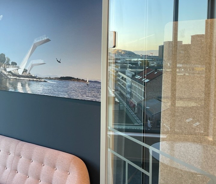 Et rom med en sofa og et bilde på veggen