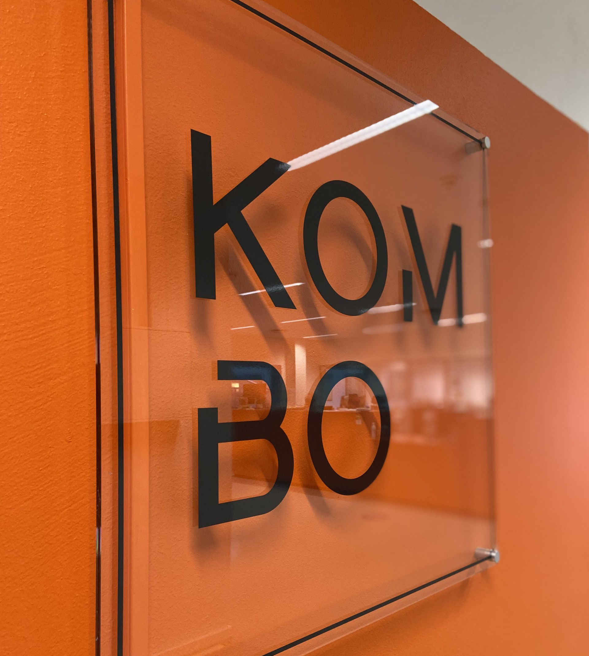 Et skilt på en oransje vegg som sier kom bo