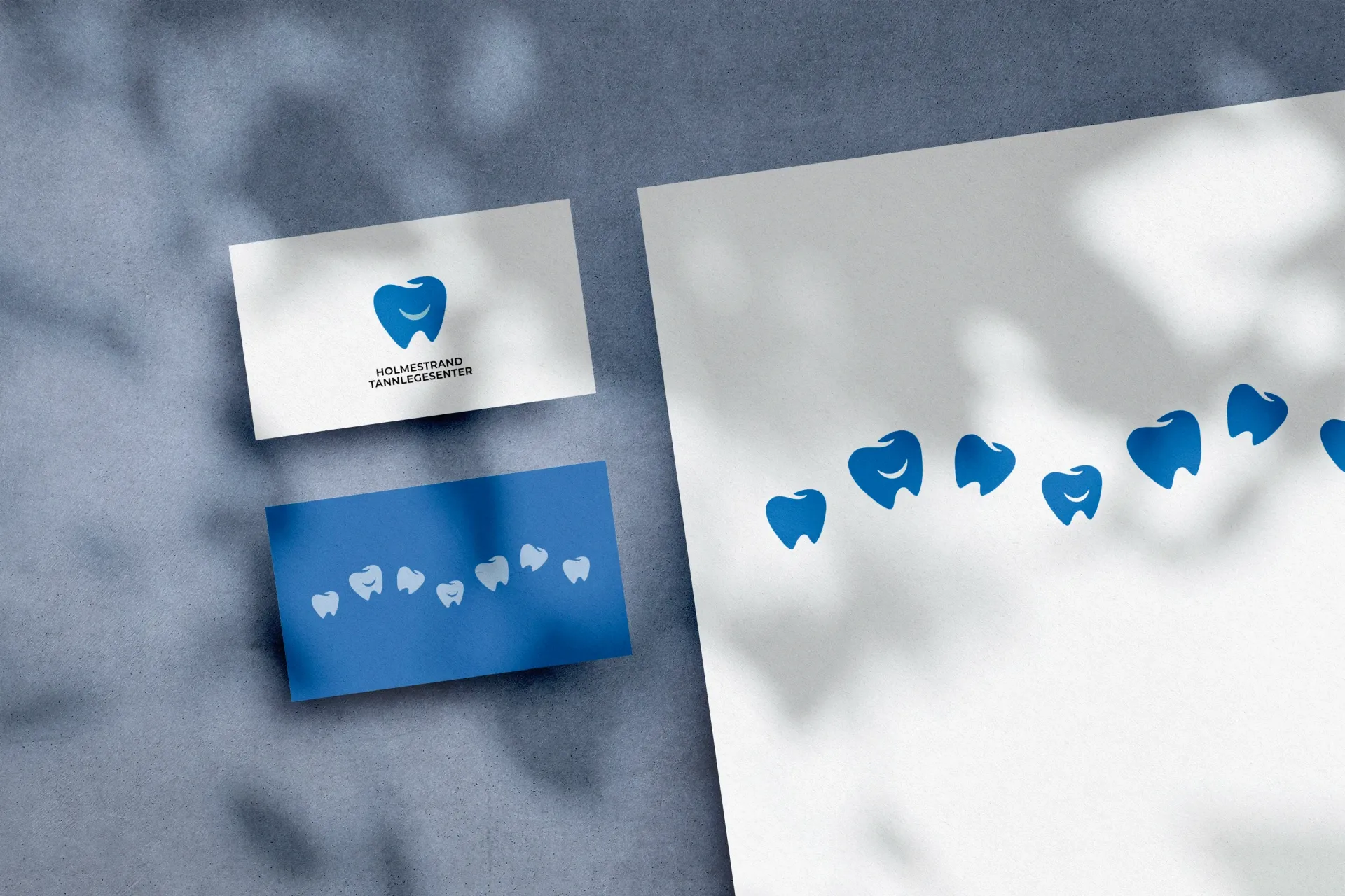 To visittkort og et stykke papir med tenner på.