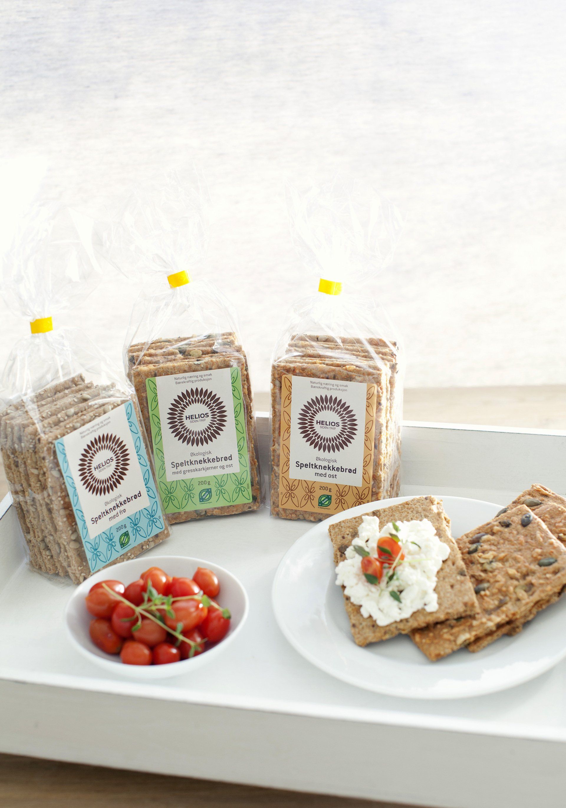 Et brett med kjeks , tomater og ost på.