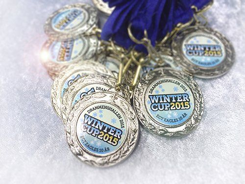 En haug med medaljer med ordene vintercup 2015 på