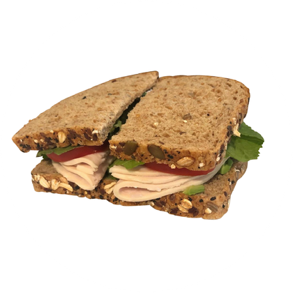 A sandwich with turkey and lettuce is cut in half from farm fresh