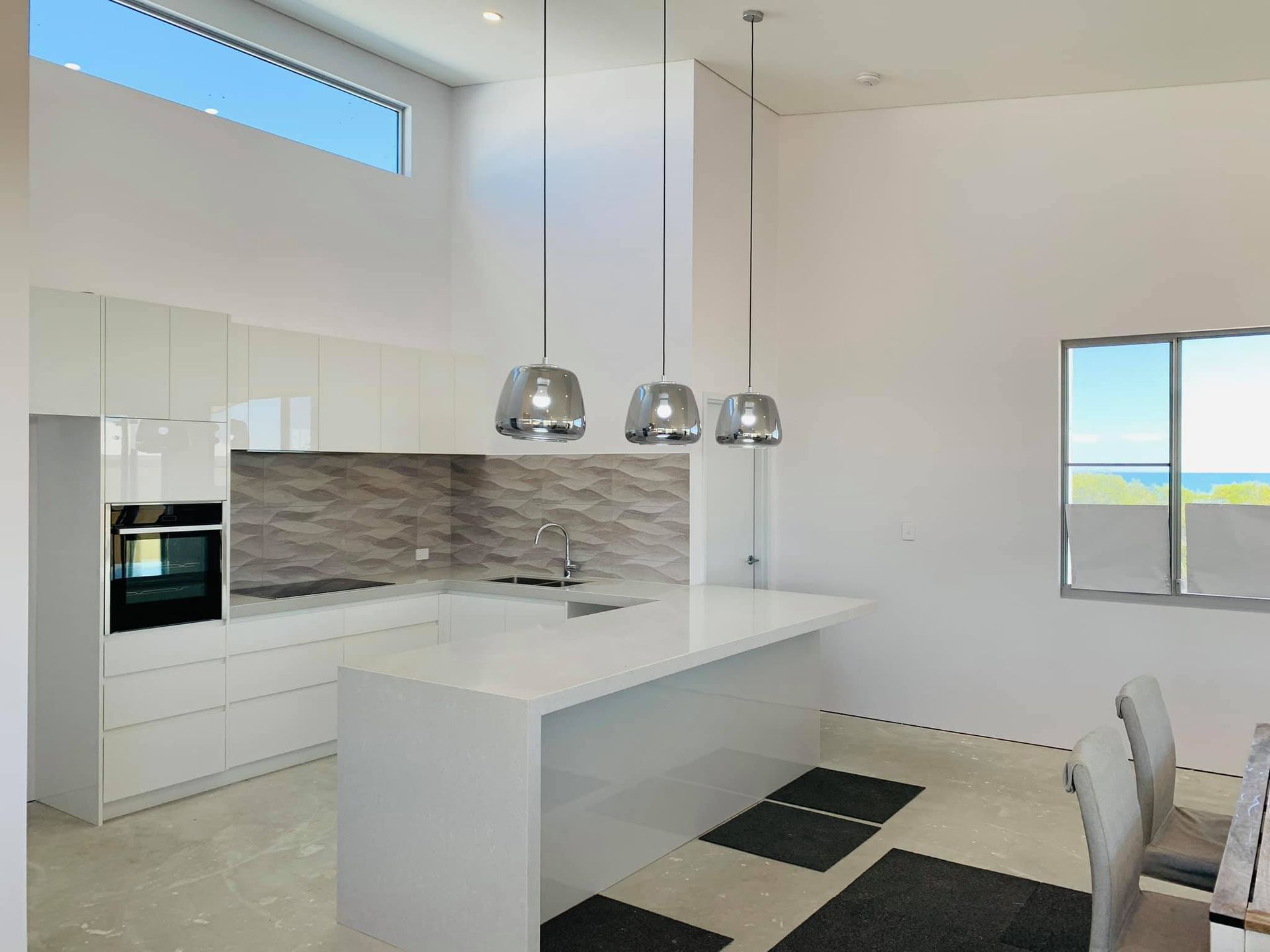 A kitchen with white cabinets and a large island in the middle of the room.