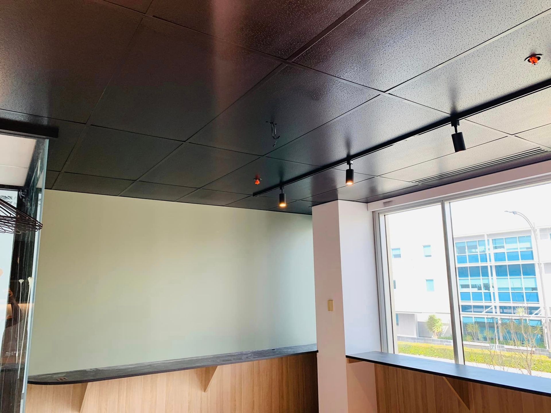 A room with a ceiling that has a lot of lights on it and a large window.